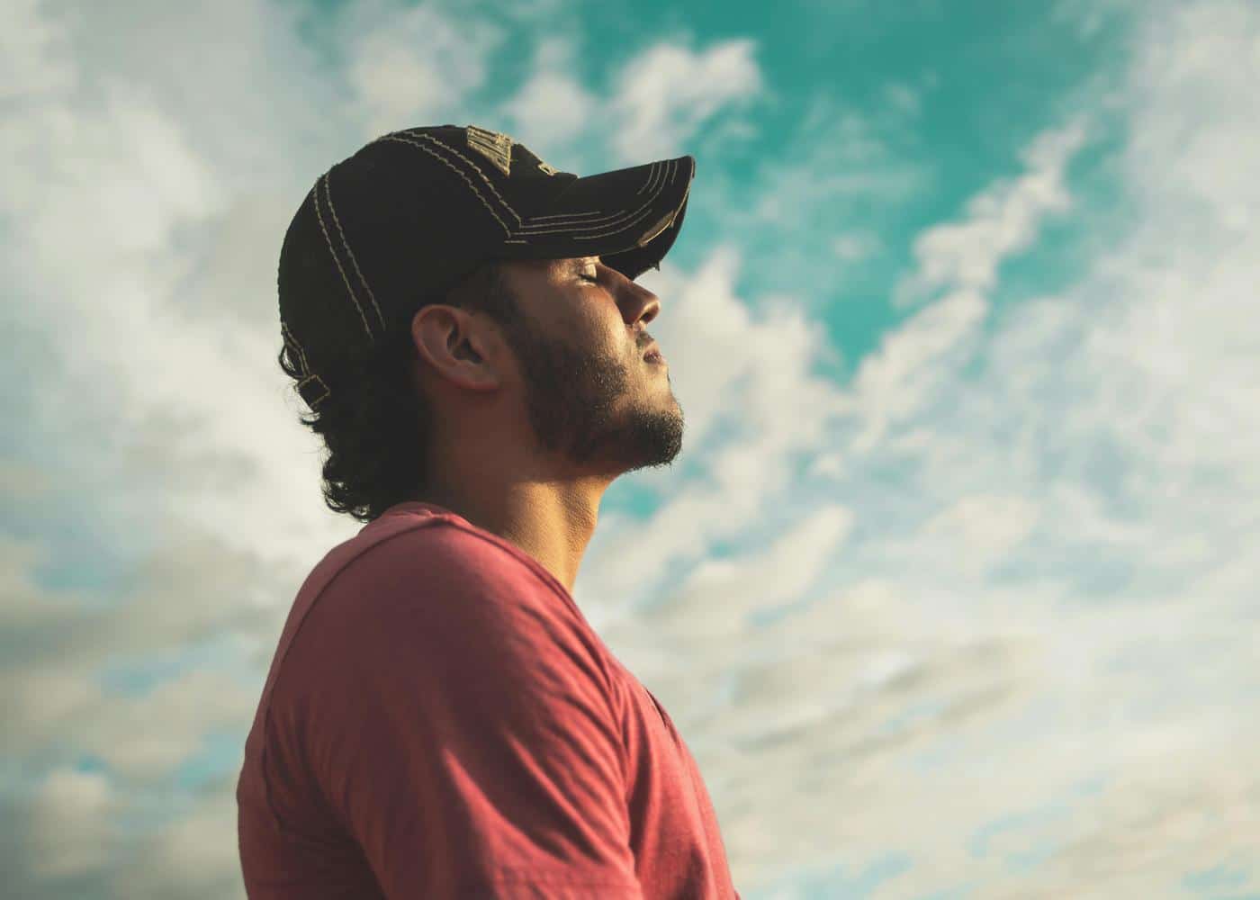 Benefits of morning meditation - Man looking relaxed against a sky backdrop