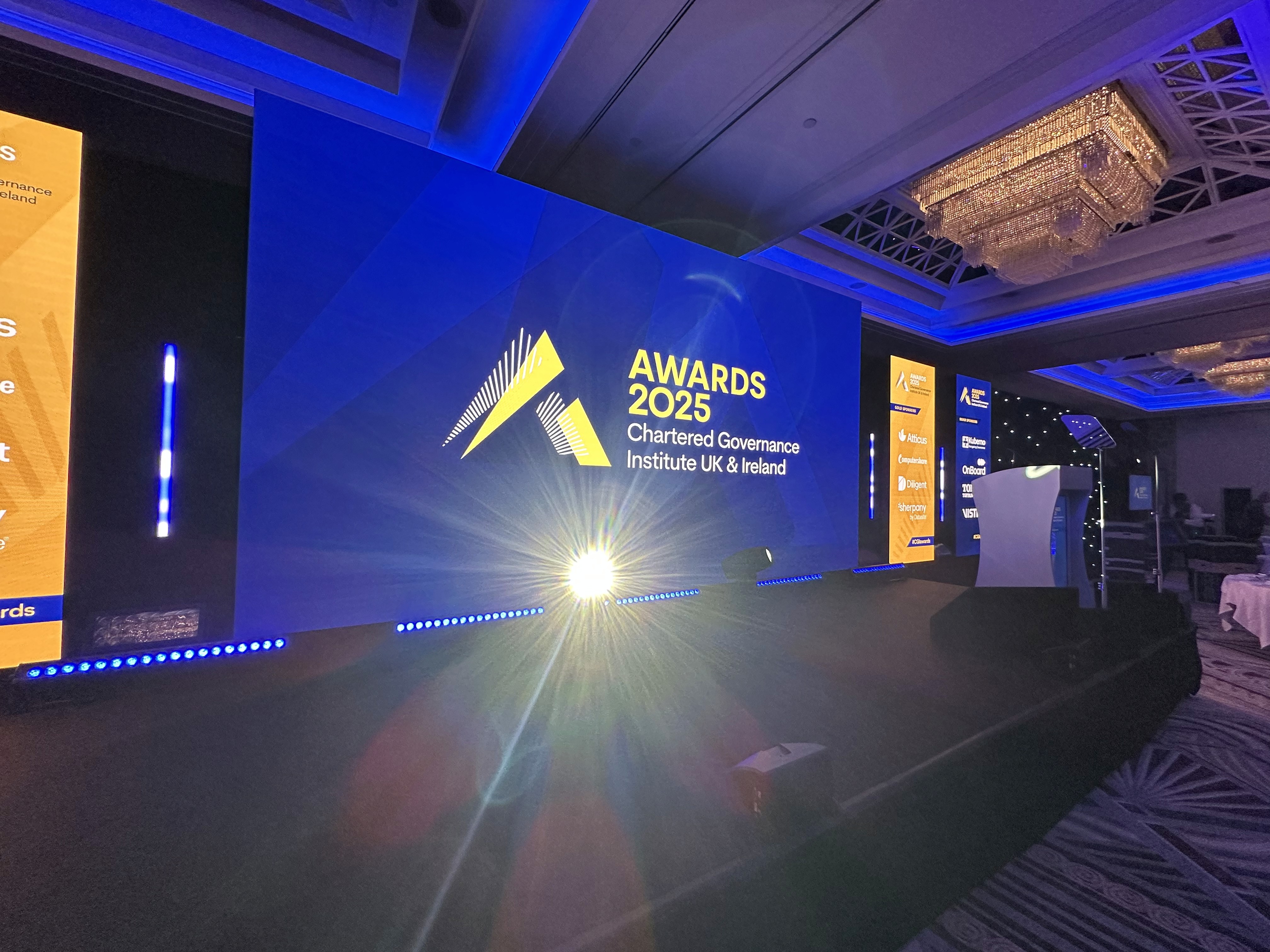 Angled view of the CGI Awards stage showing the central LED screen, lighting effects and sponsor displays.