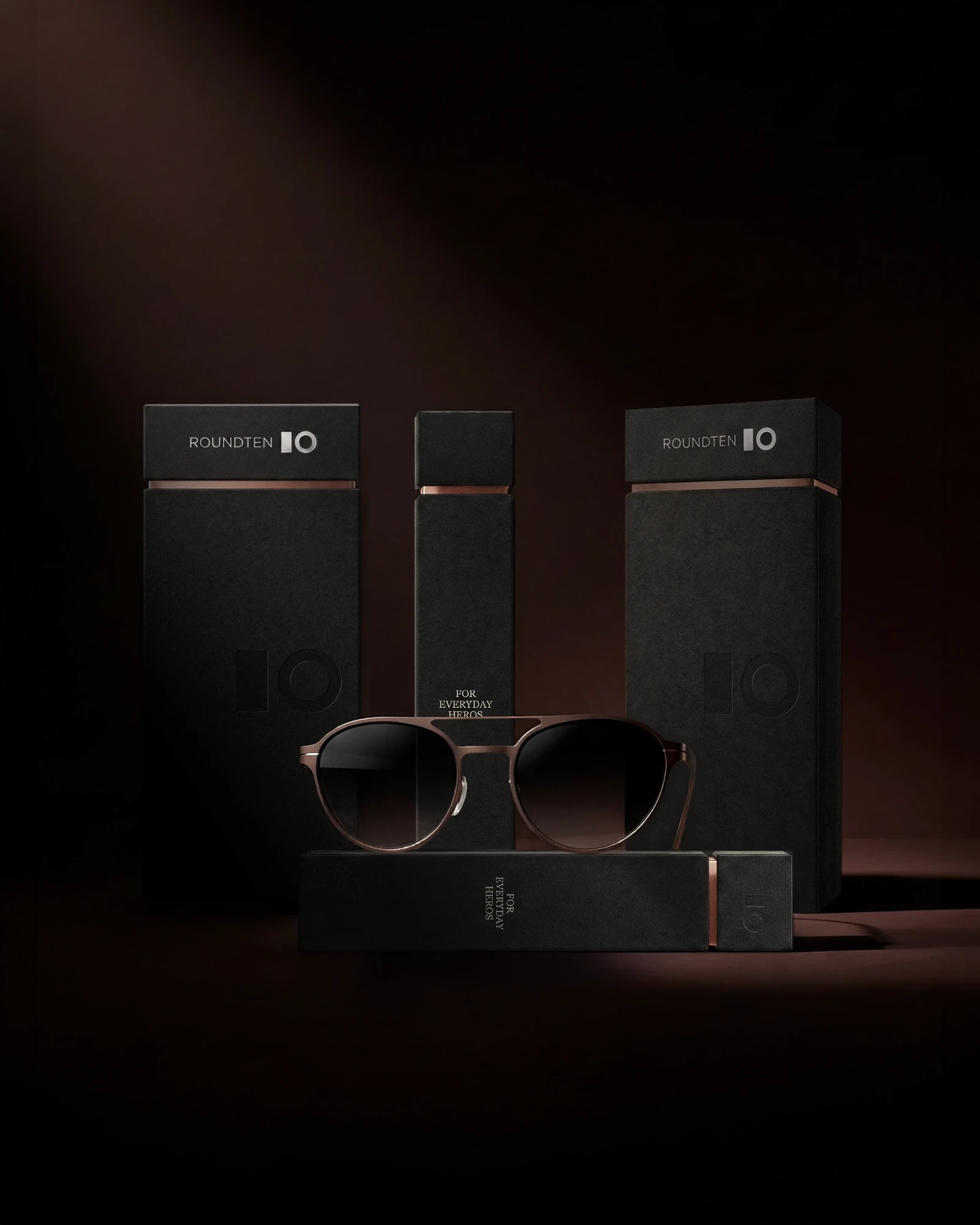 Roundten Mascherano Signature black packaging boxes and sunglasses on a dark set, packaging design by Sebastian Saavedra