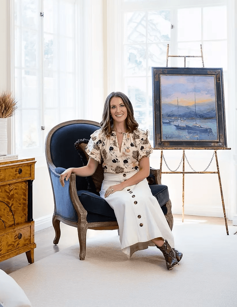 A person with short blonde hair holds a vintage camera.