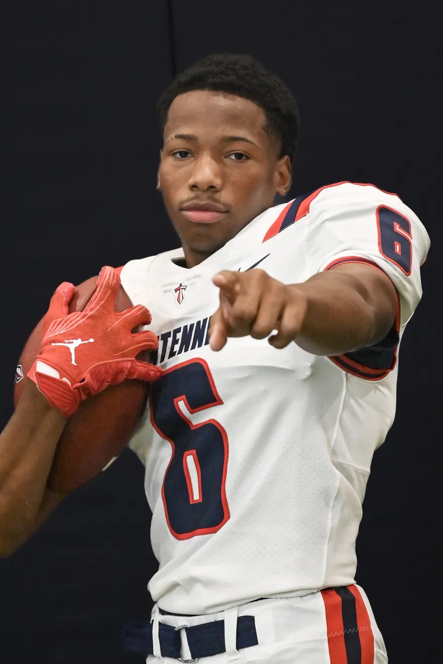 Karmelo in football uniform holding a football