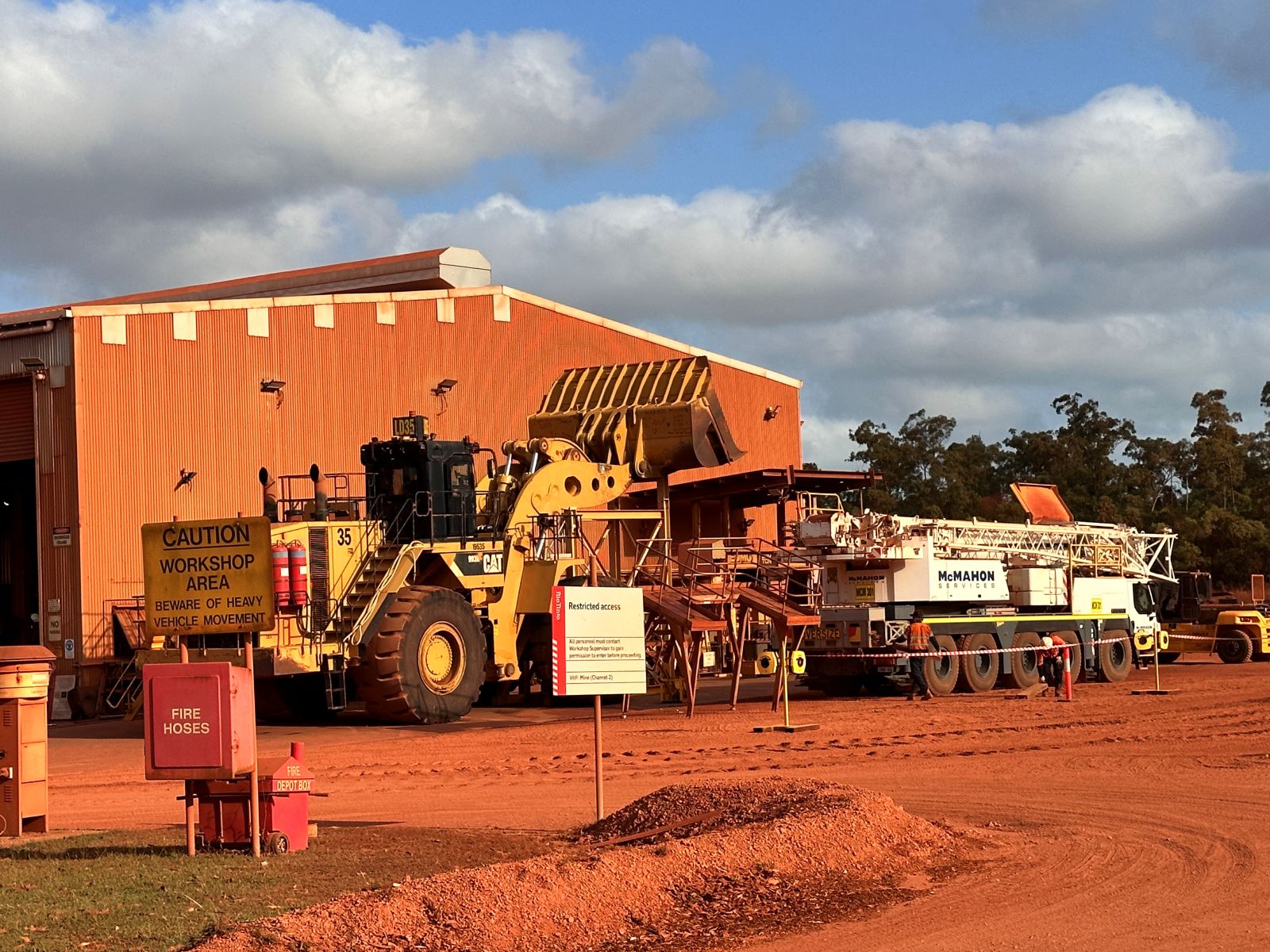Heavy mobile equipment and workshop operations at an active mining site, supported by UMINEX engineering, procurement, and on-site project delivery services