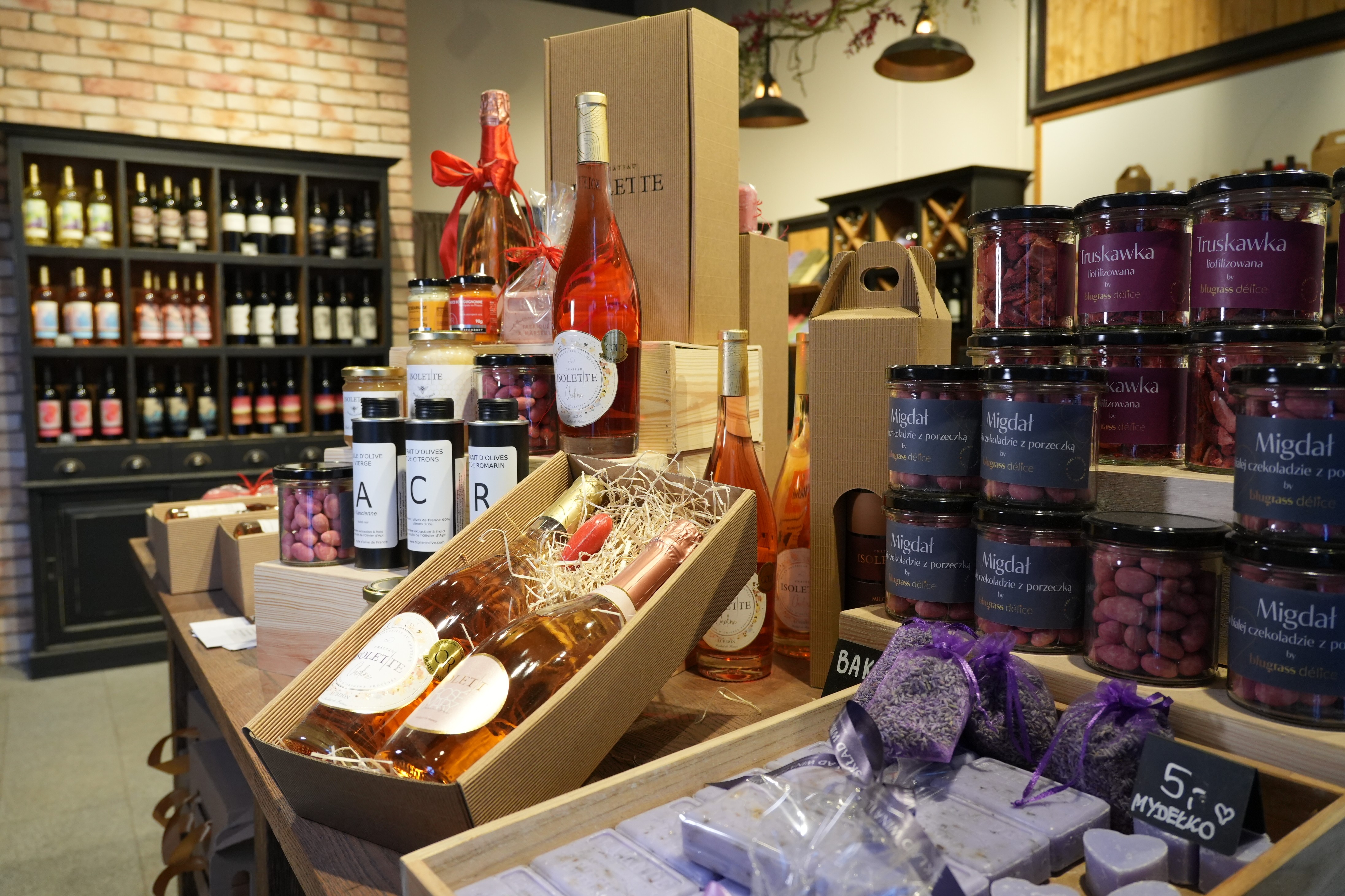 Zdjęcie sklepu Skład Wina i Lawendy. Butelki wina leżą na zapakowanych kartonach. 