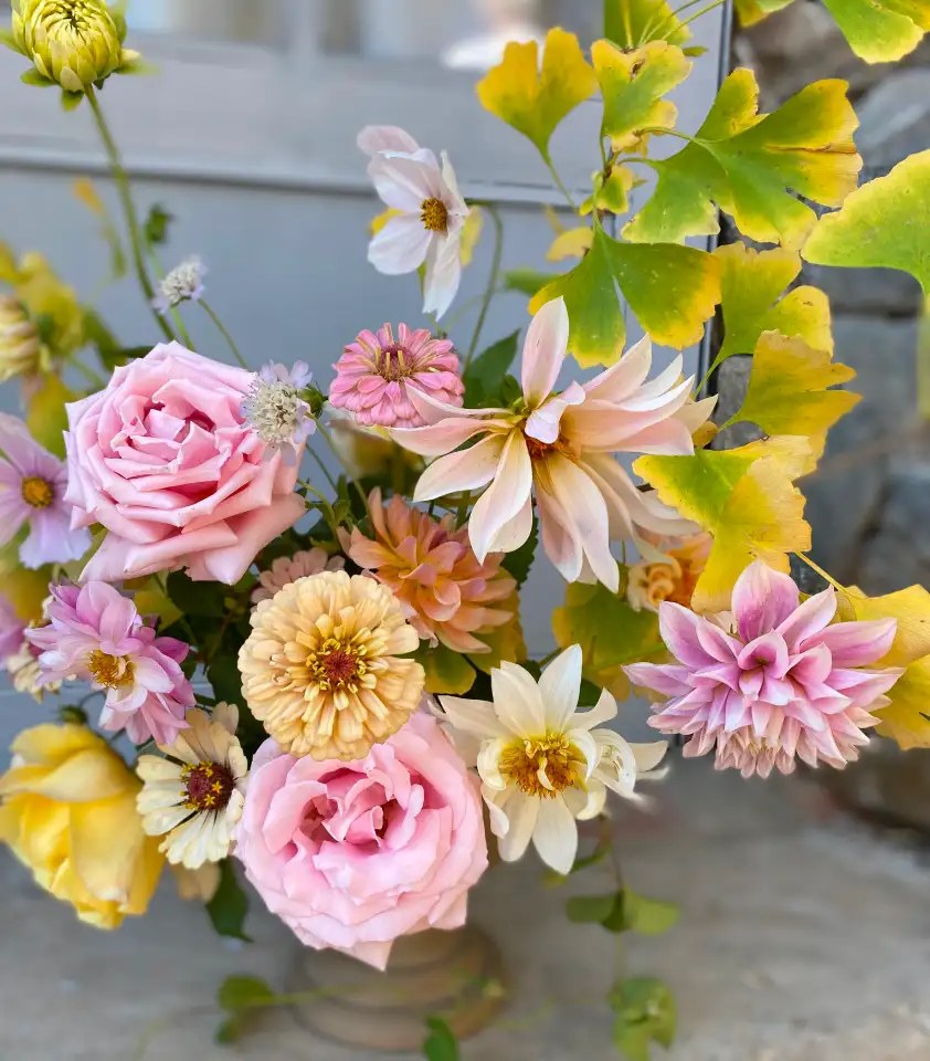 Arreglo floral luminoso con rosas, dalias y zinnias en tonos pastel, diseño botánico delicado y armónico.