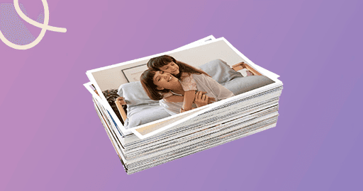 Pessoa segurando Fotolivro com foto em preto e branco de mãe beijando o filho recém-nascido, com o nome Pedro Henrique escrito na imagem