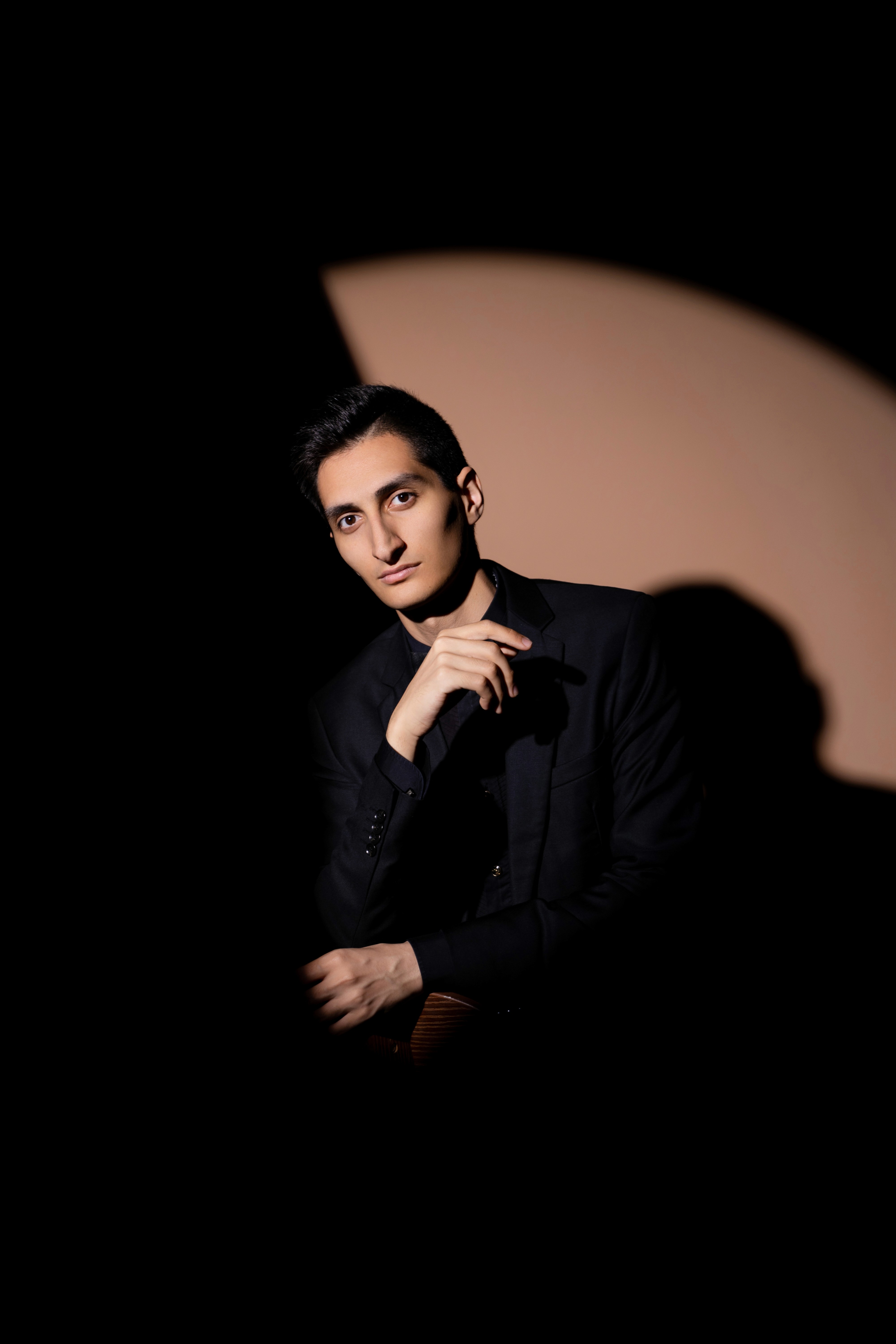     Erik Mirzoyan seated in a dark studio portrait