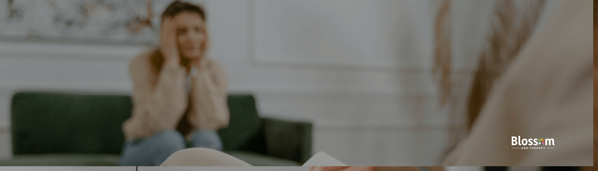 Teenager sitting on a couch speaking with a therapist during a counseling session in a cozy, organized office.