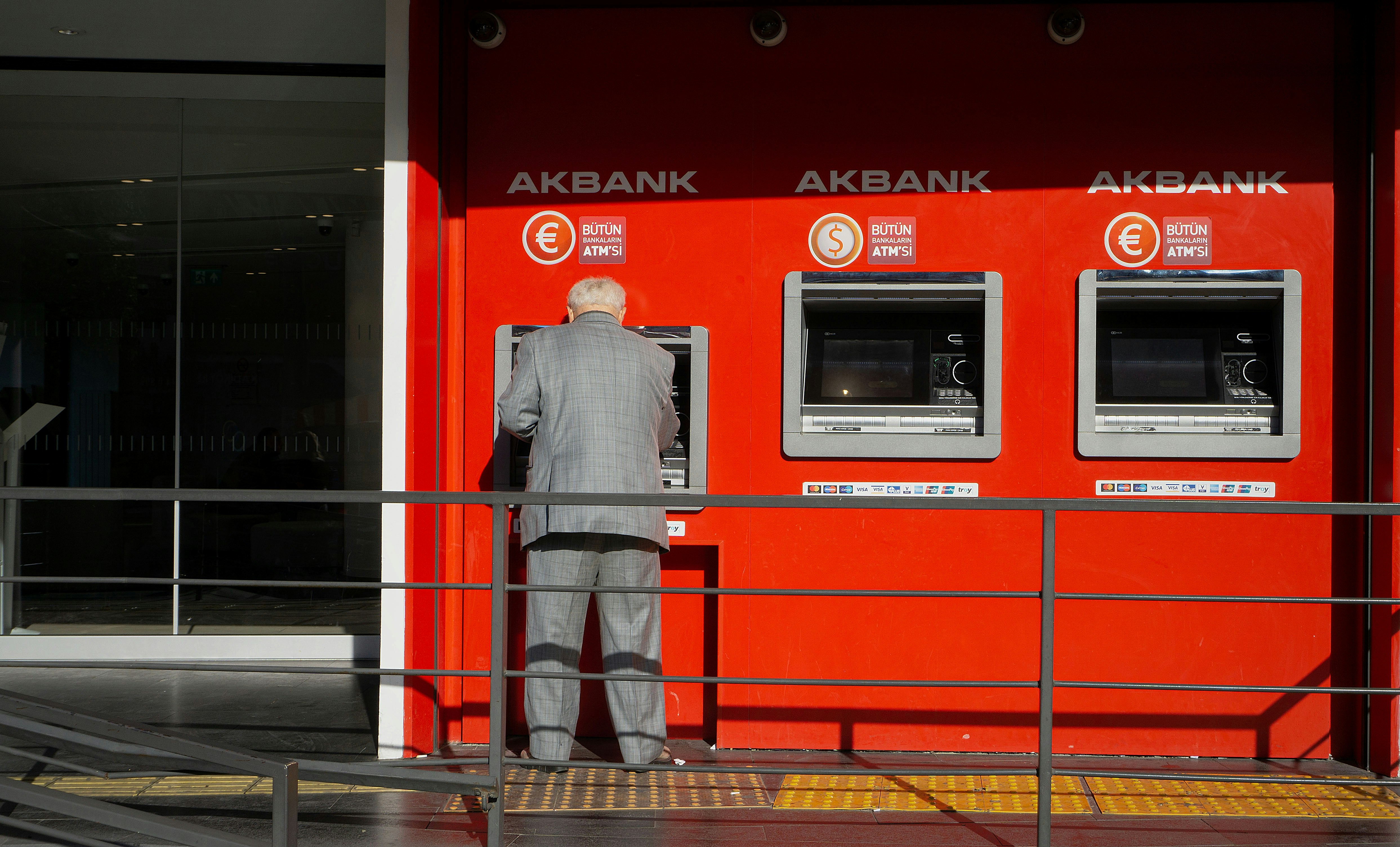 Man standing at red ATM machine