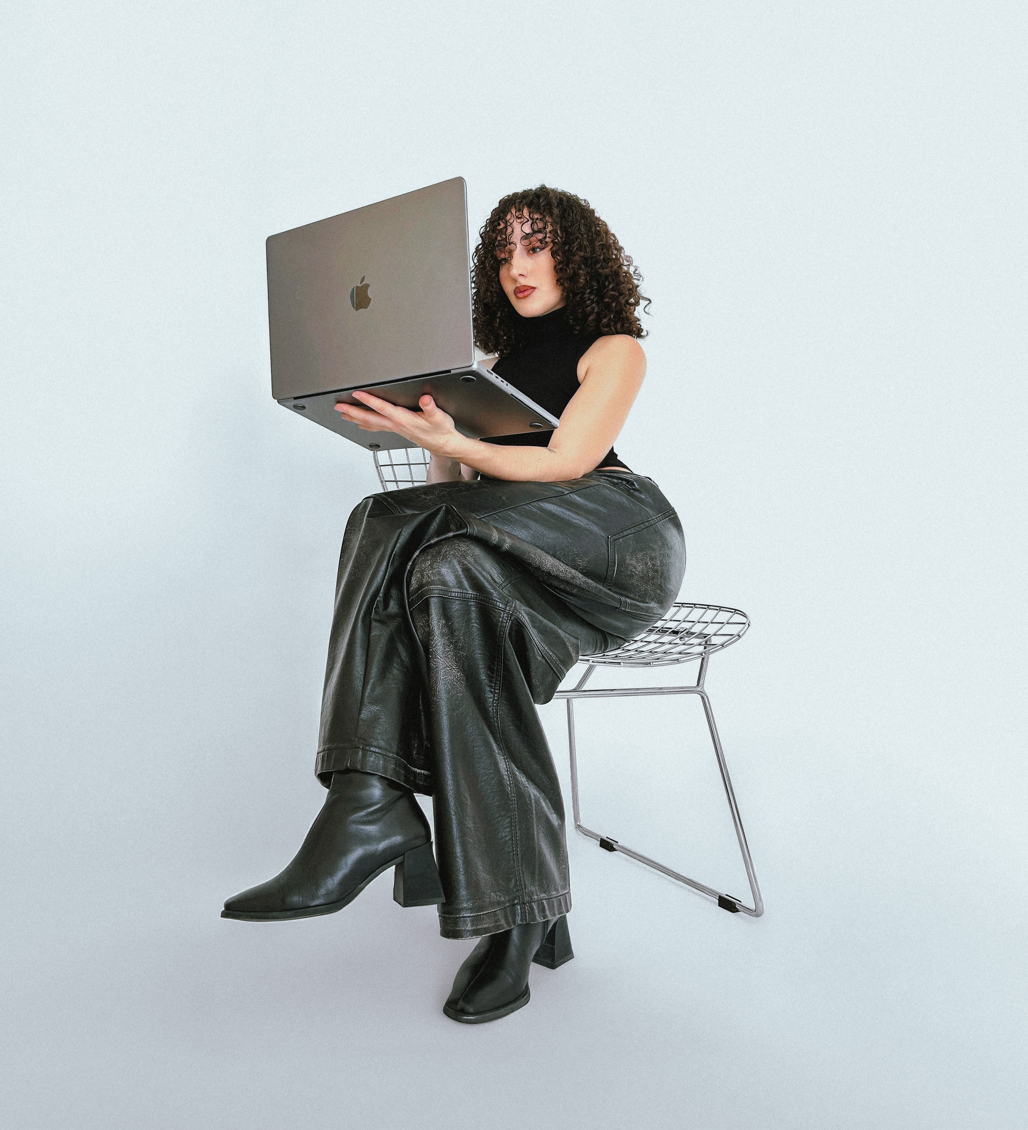 A view of a studio interior with modern decor, featuring large windows that offer a glimpse of lush greenery outside