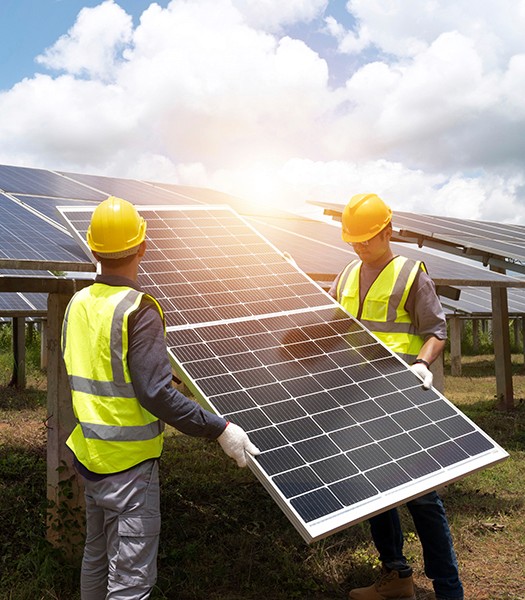 Technician installing solar panels on a solar farm