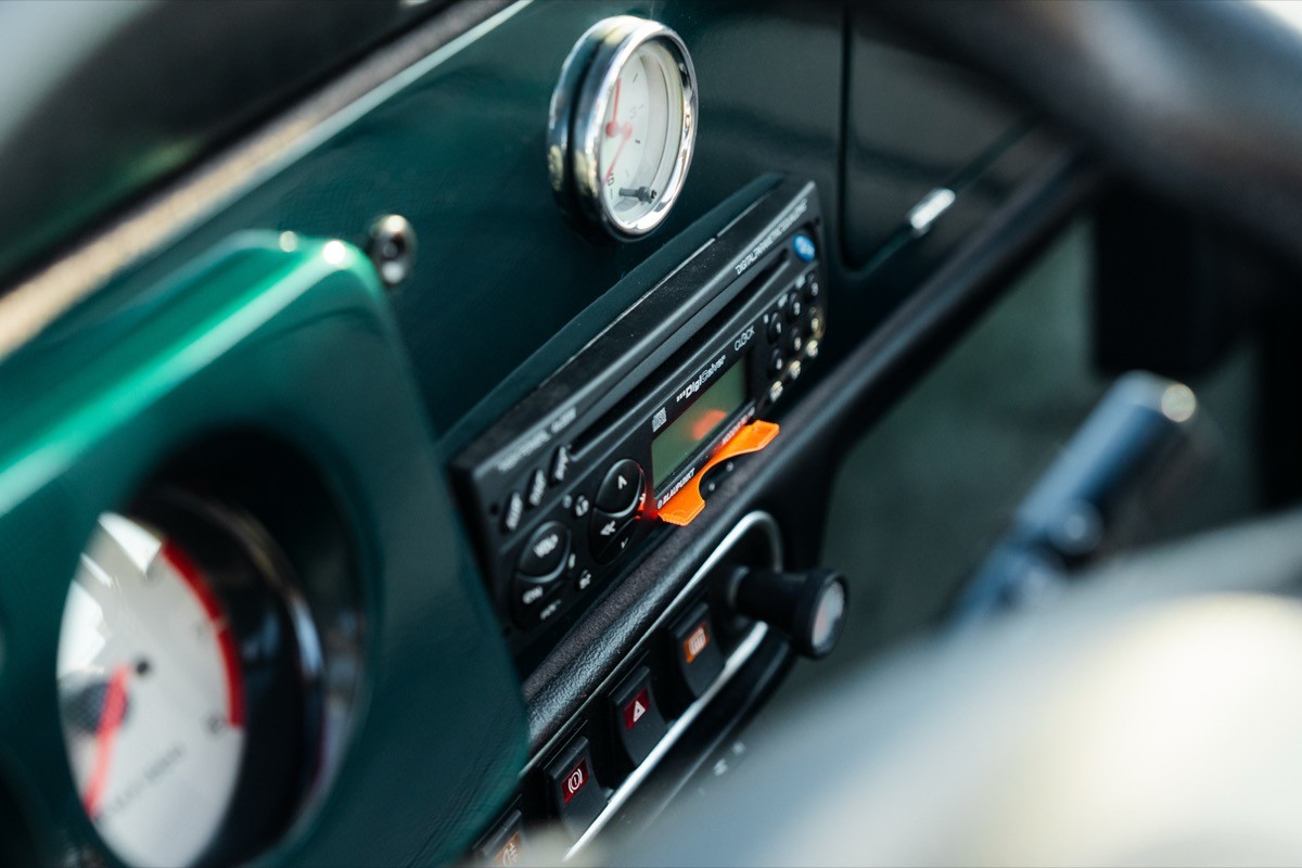 Close-up of a car dashboard featuring a vintage radio and gauges in a stylish interior.