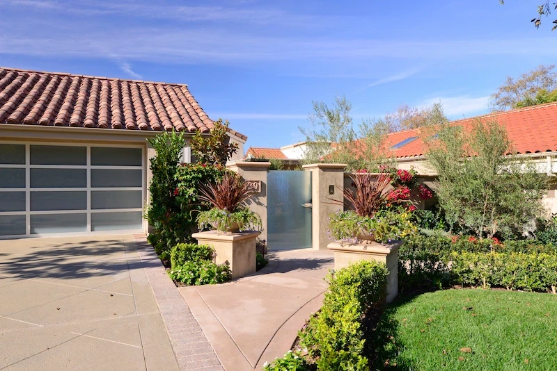 Courtyard entrance of Harbor Ridge Transitional Remodel with gate and terracotta roof detail.