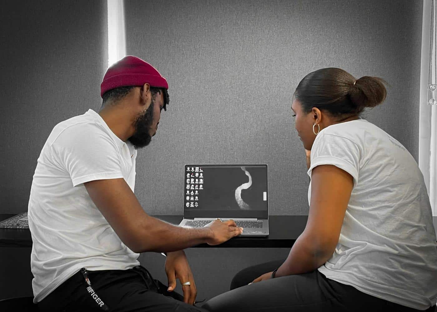 Man showing a woman a fitness coaching app on a computer