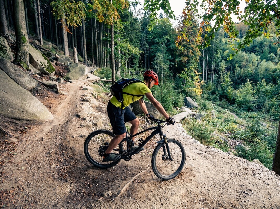 man using a mountain bike outdoors after learning how to start cycling to lose weight