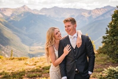 Clemmie rests an arm around Tucker's shoulders as they smile together at the overlook.