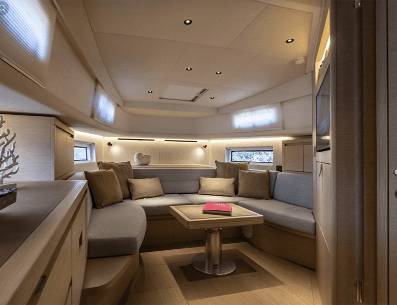 Corner shot from the kitchenette, capturing the compact dining area, sofa, and bed area in one flowing layout.