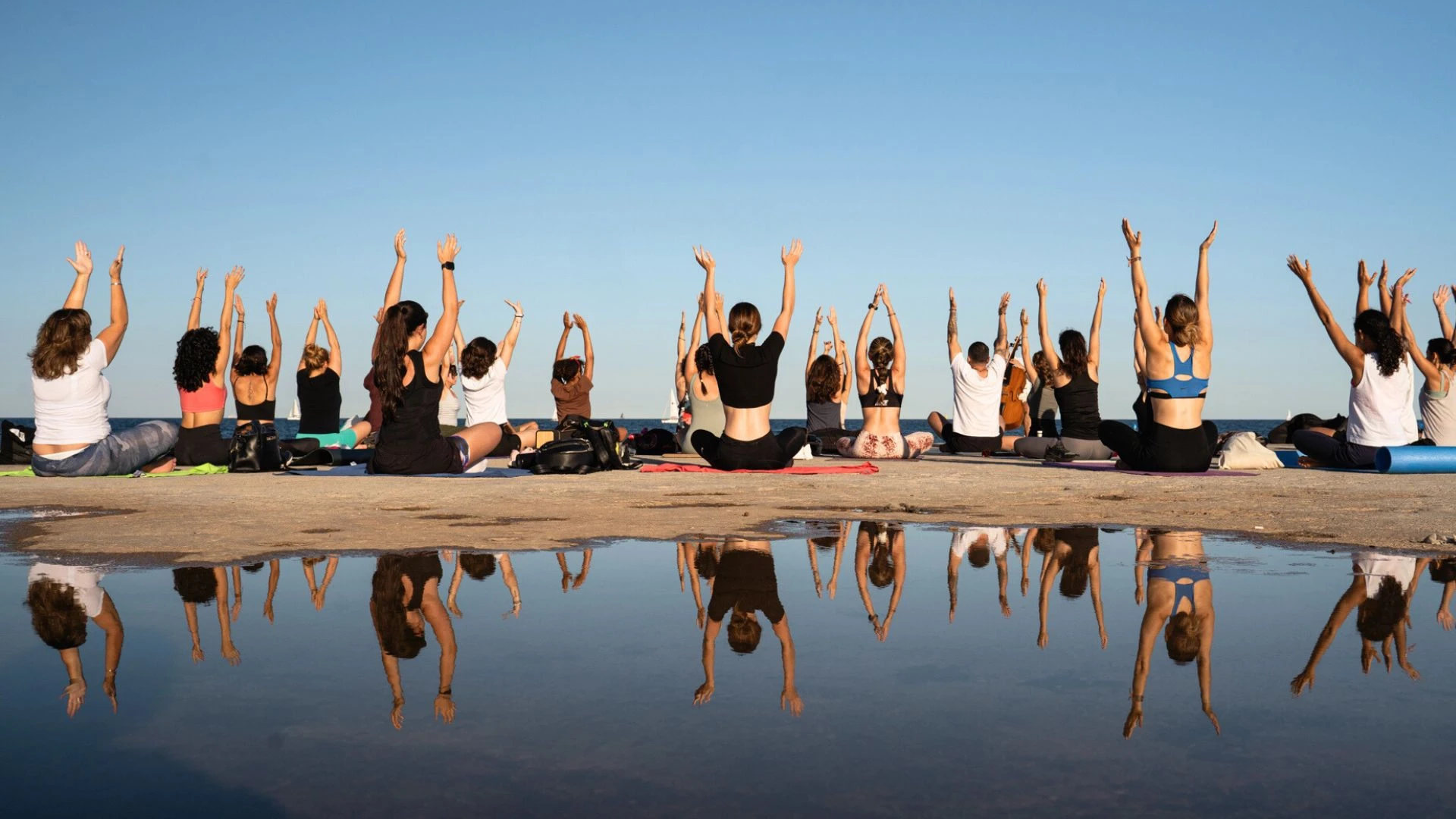 Group of yogis practising yoga at the beach