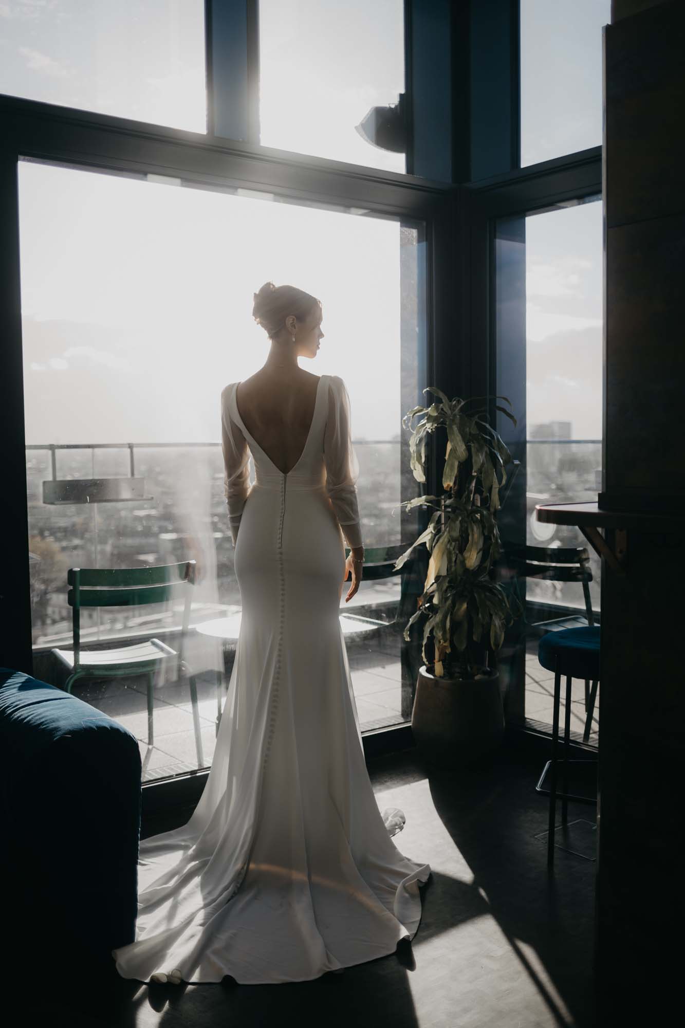 Braut schaut von einer Rooftopbar über Düsseldorf.