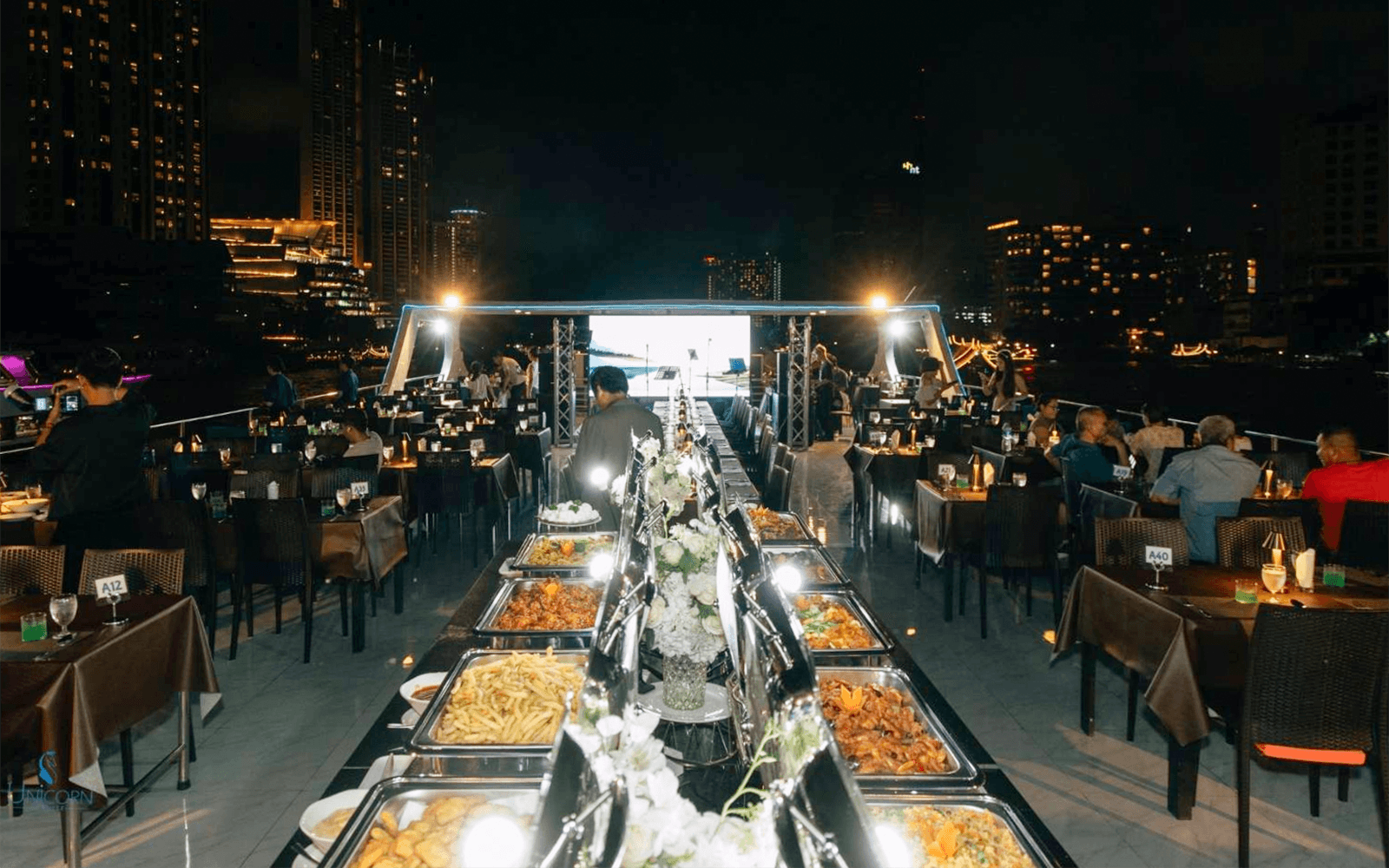 曼谷的獨角獸晚餐郵輪上設置自助餐，夜晚的城市天際線。