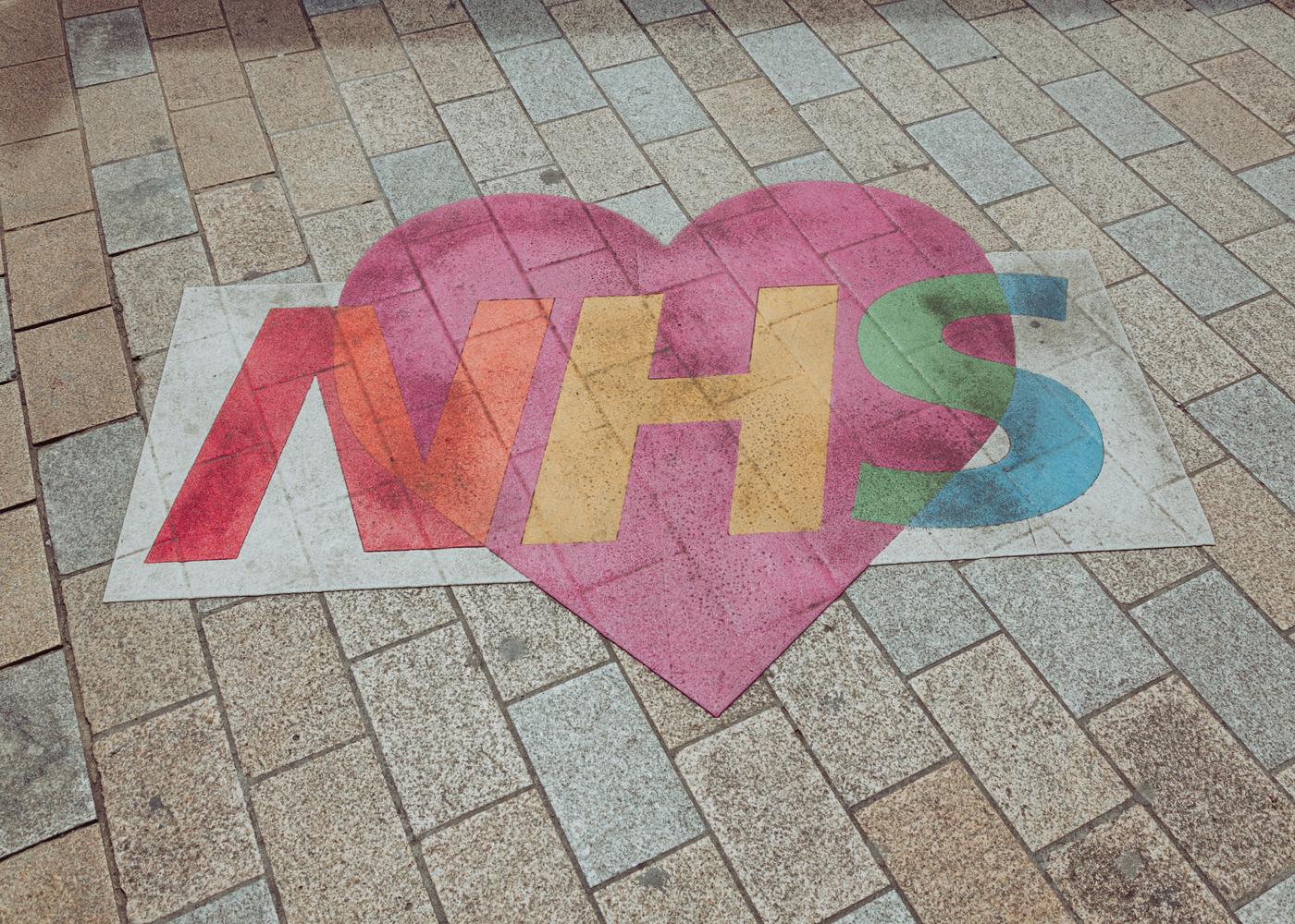 NHS logo overlaid on a heart and painted on the sidewalk