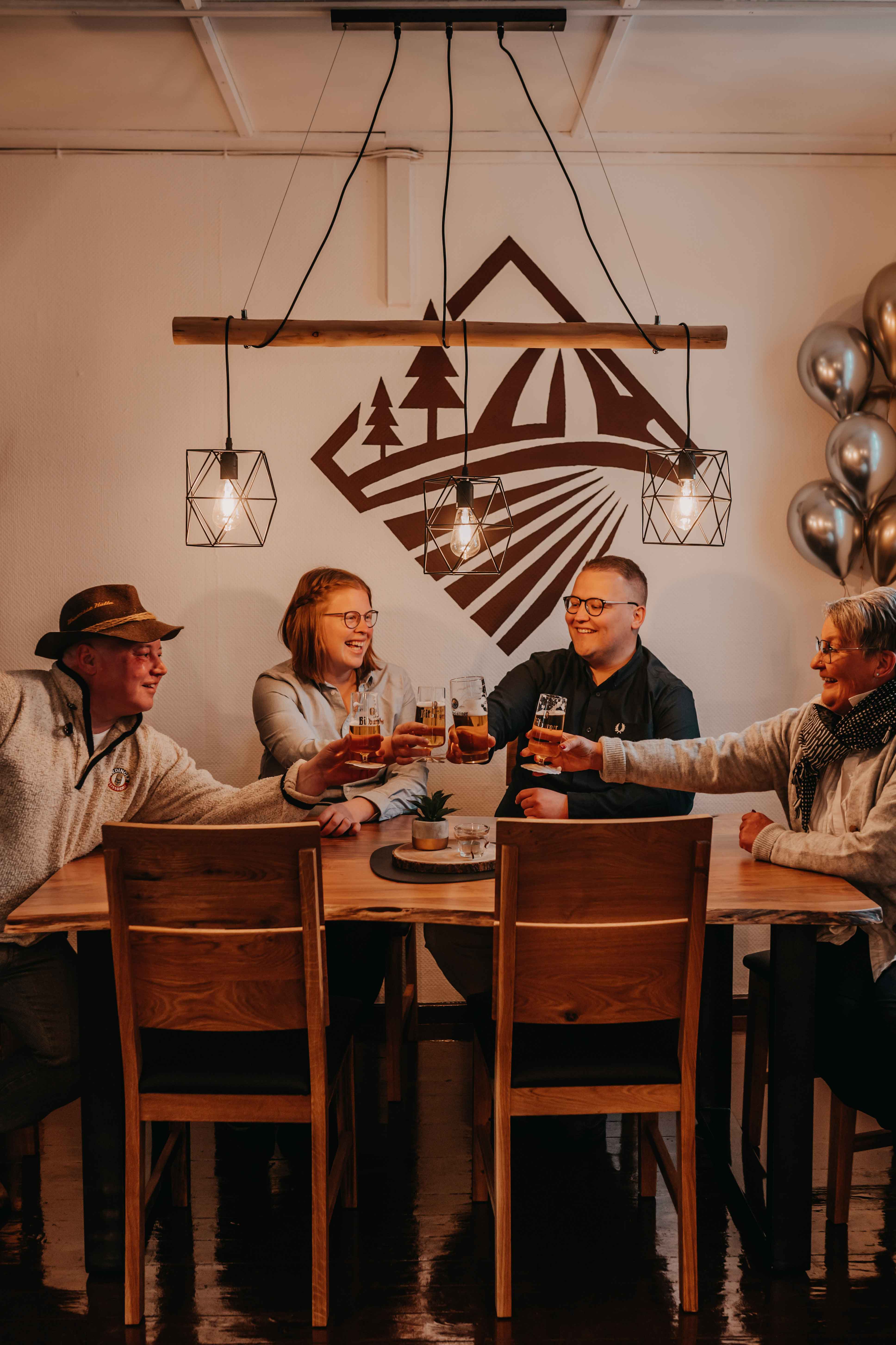 4 Personen die an einem Tisch anstoßen