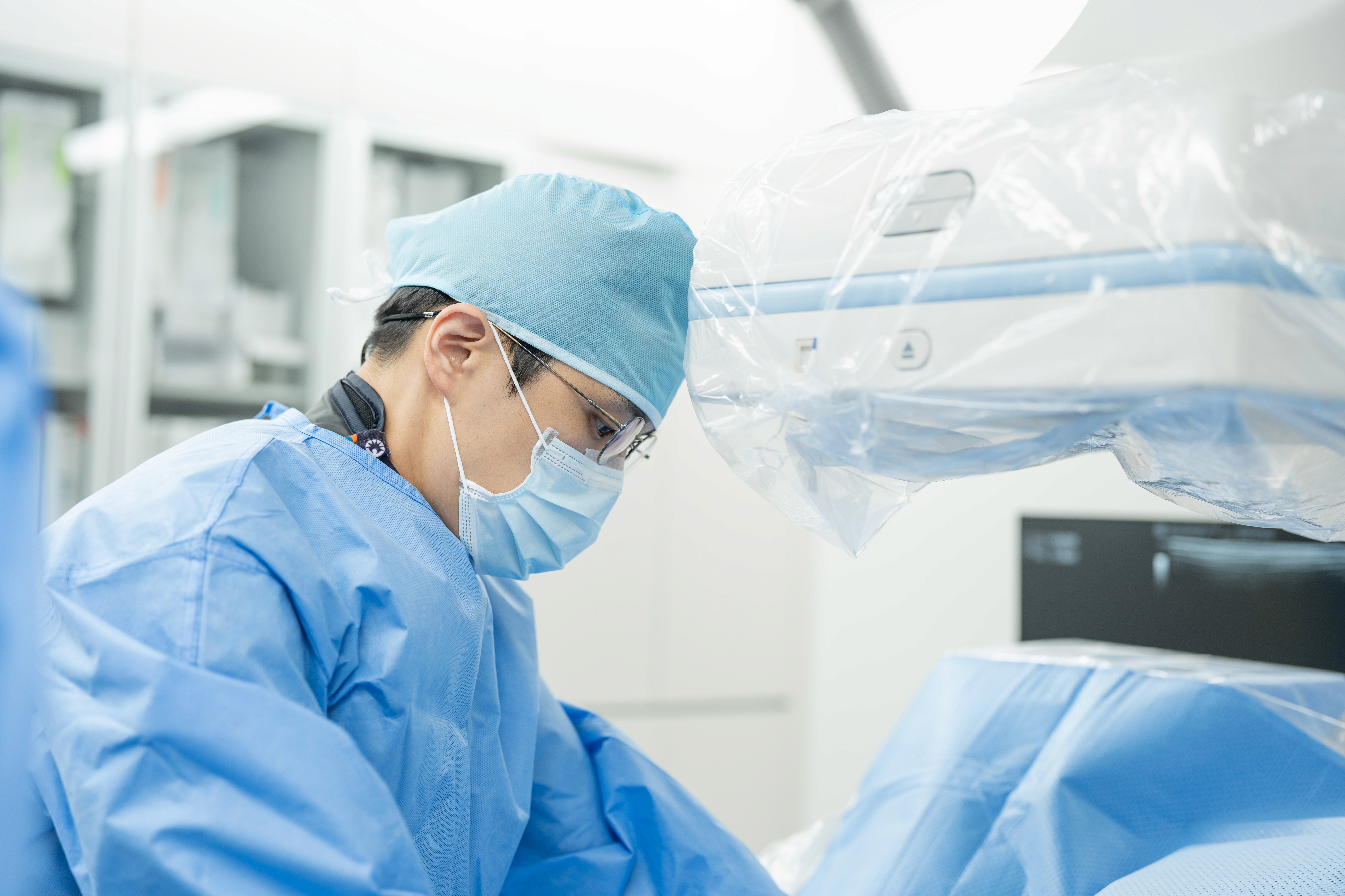 이상준 원장이 수술복을 입고 혈관조영실에서 시술을 하고 있다.