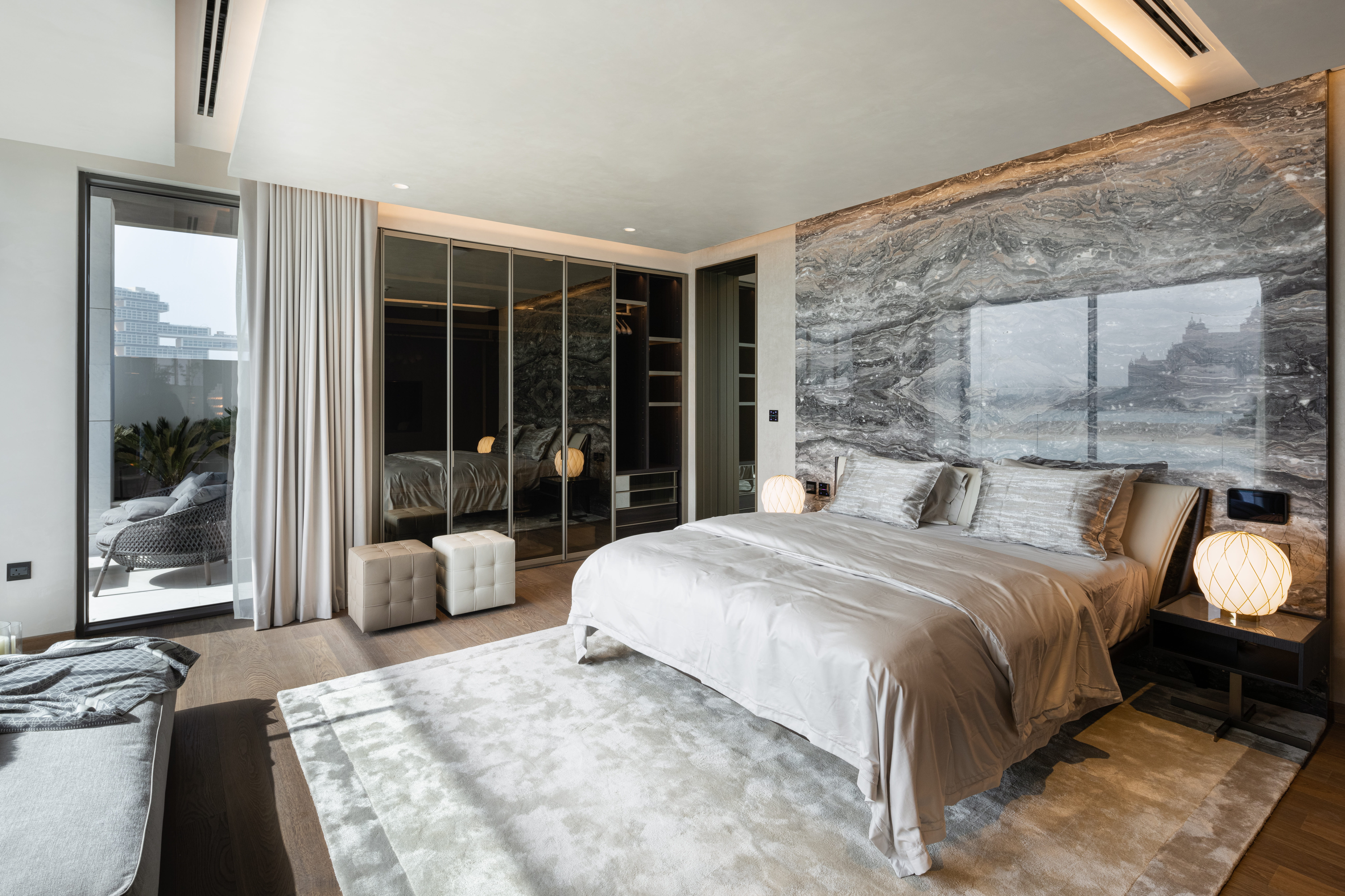 MW Interior Hoteleinrichtung – helles geräumiges Hotelzimmer mit großem Bett, Glasfront und elegantem Steindekor