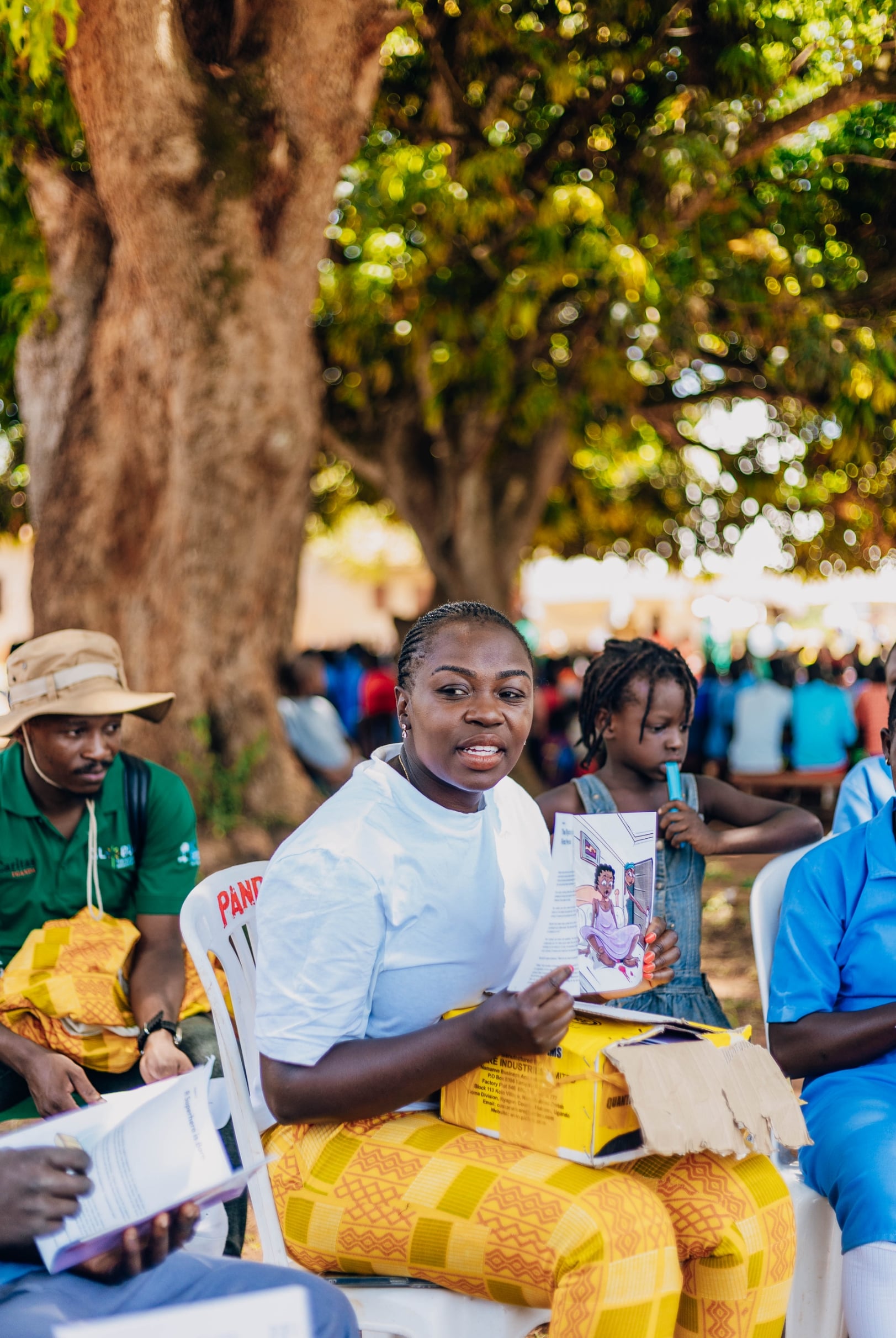 Founder holding a printed educational book designed by She For She
