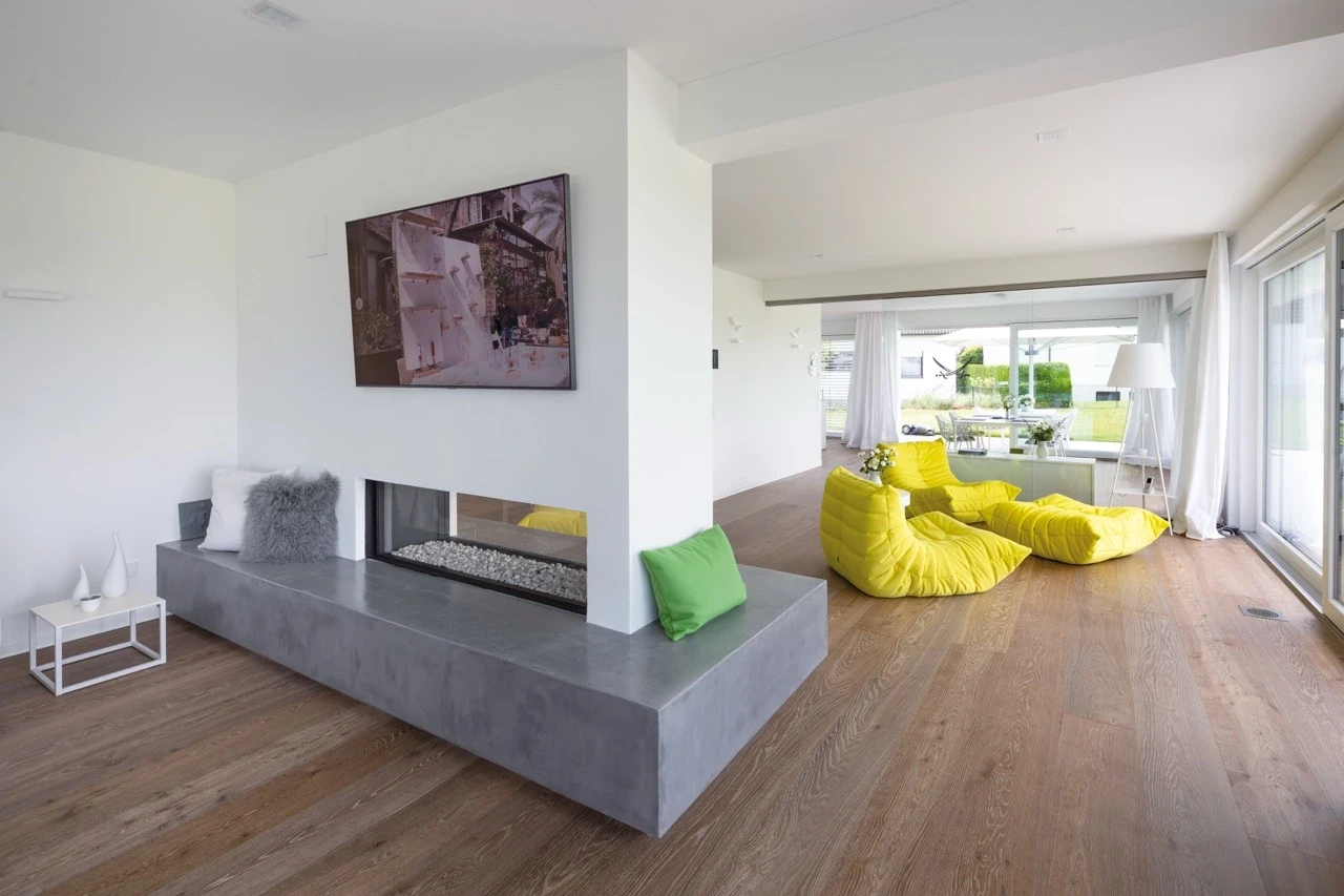 Modern living room with yellow chairs and a minimalist fireplace.