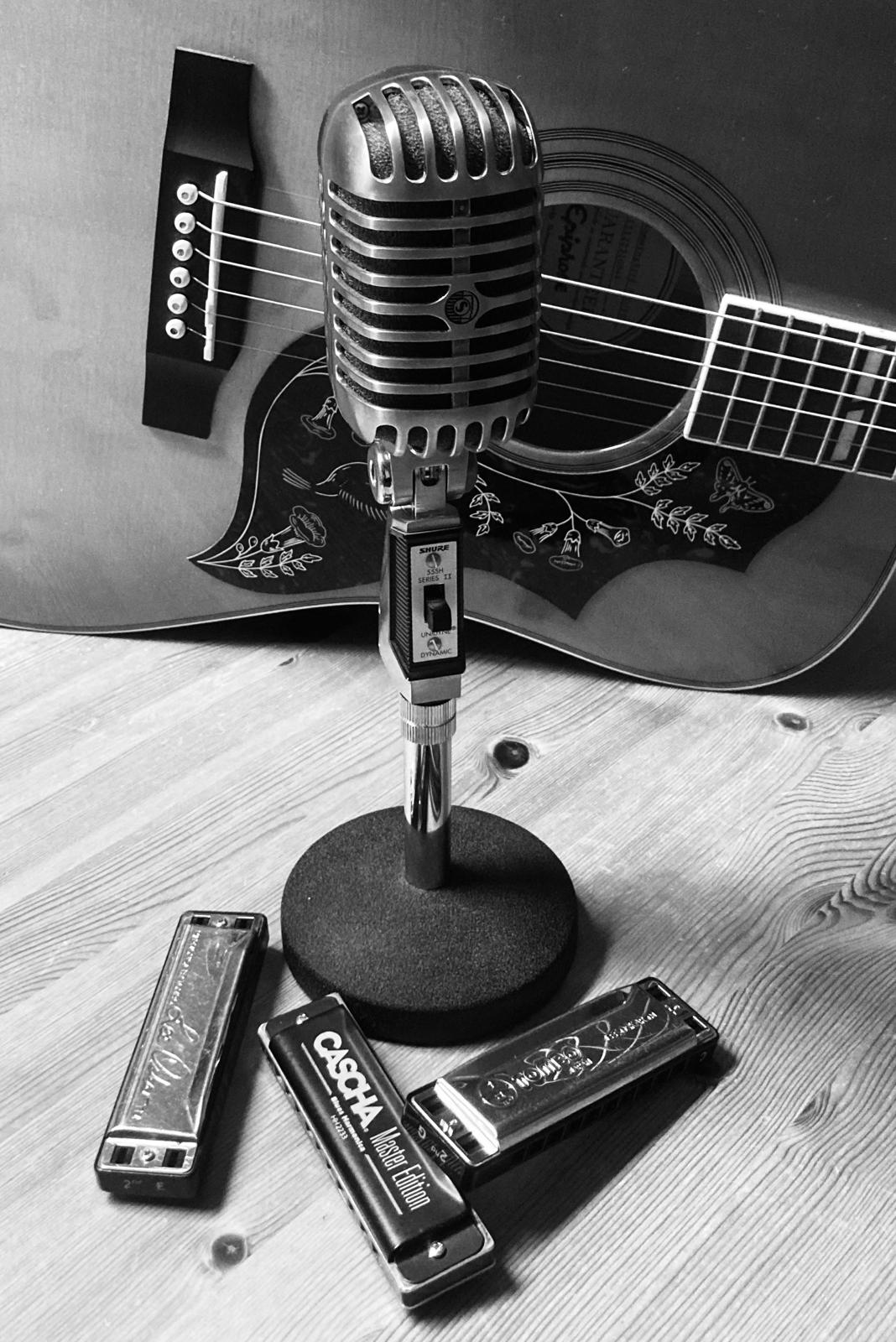 Schwarzweißfoto von Mikrofon, Gitarre und Bluesharps