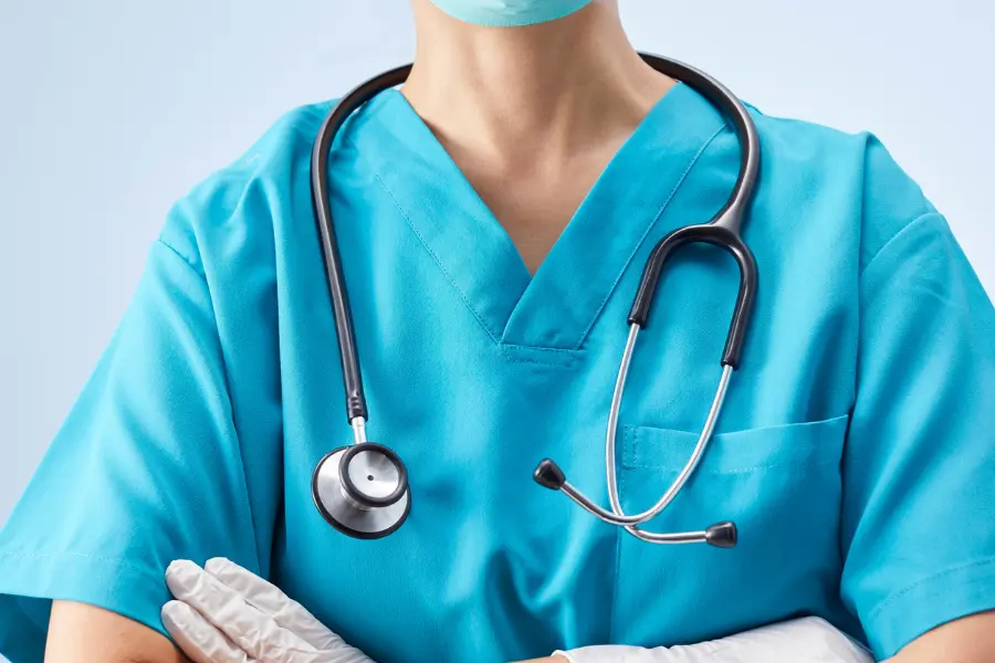 Medical AI companies symbolized by healthcare professional in scrubs with stethoscope and gloves.