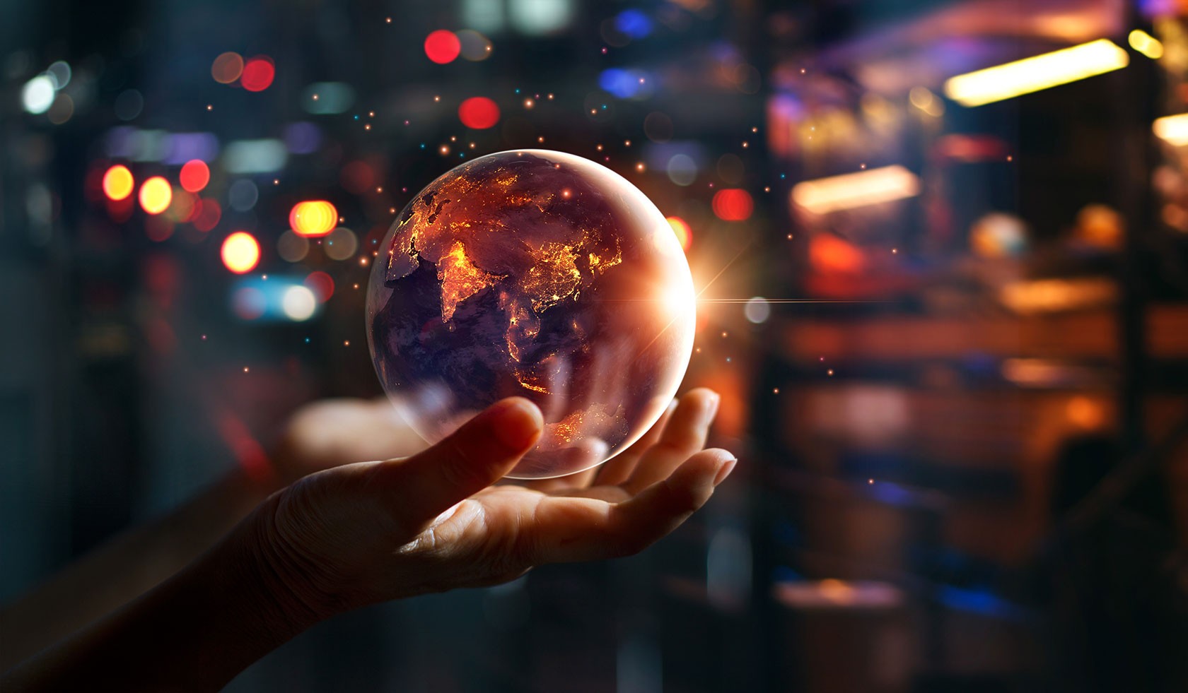 a hand holding a glowing world with blur dark city lights effect background