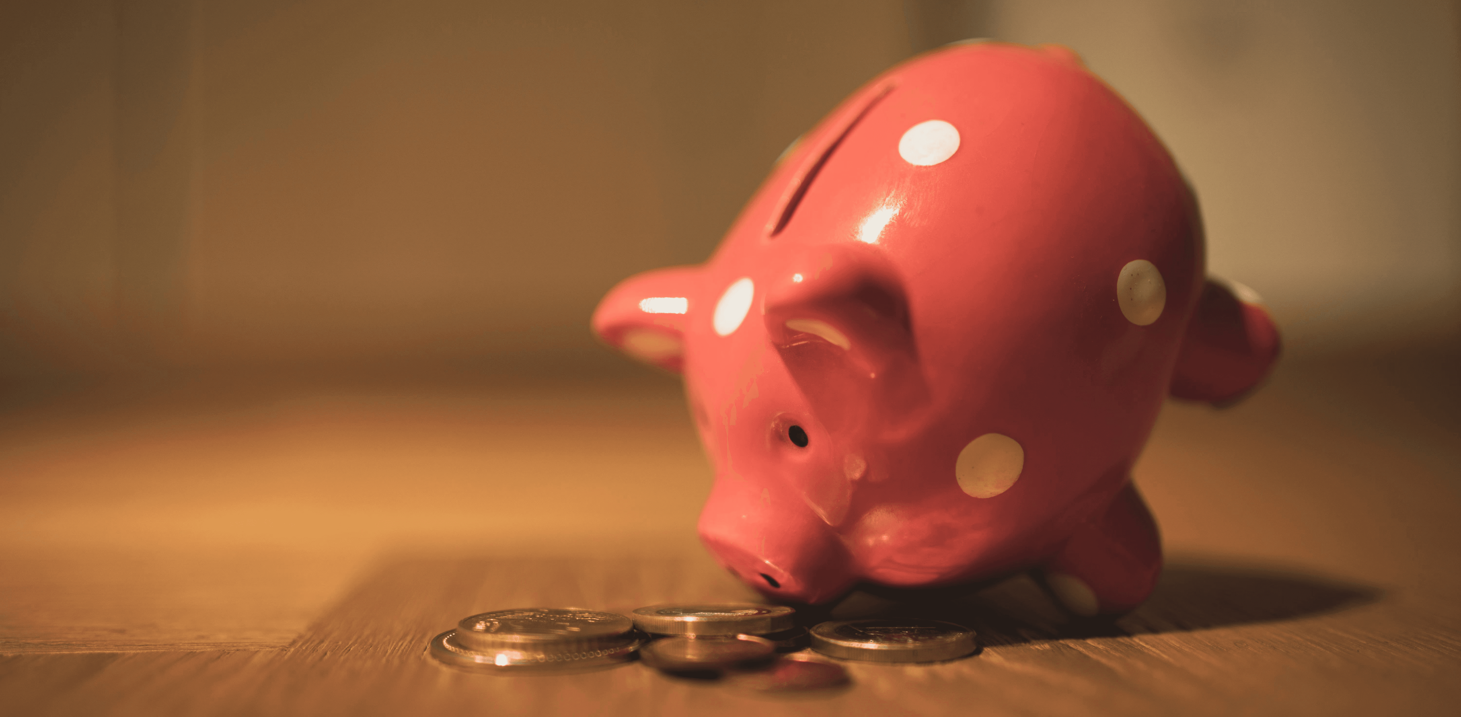 pink pig coin bank on brown wooden table