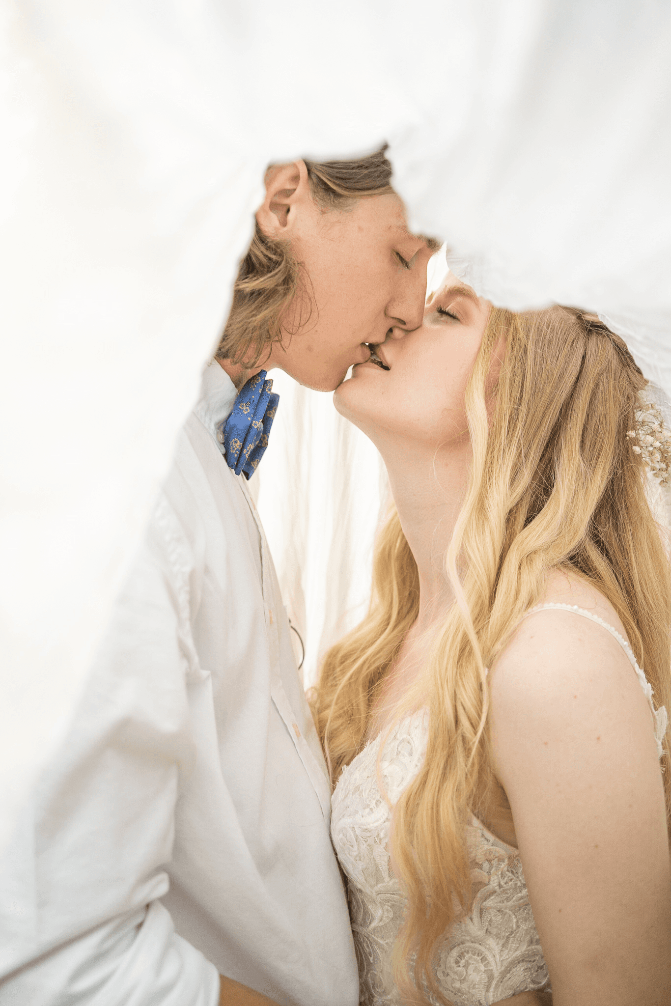  a woman and a man kiss, kissing gently under a veil