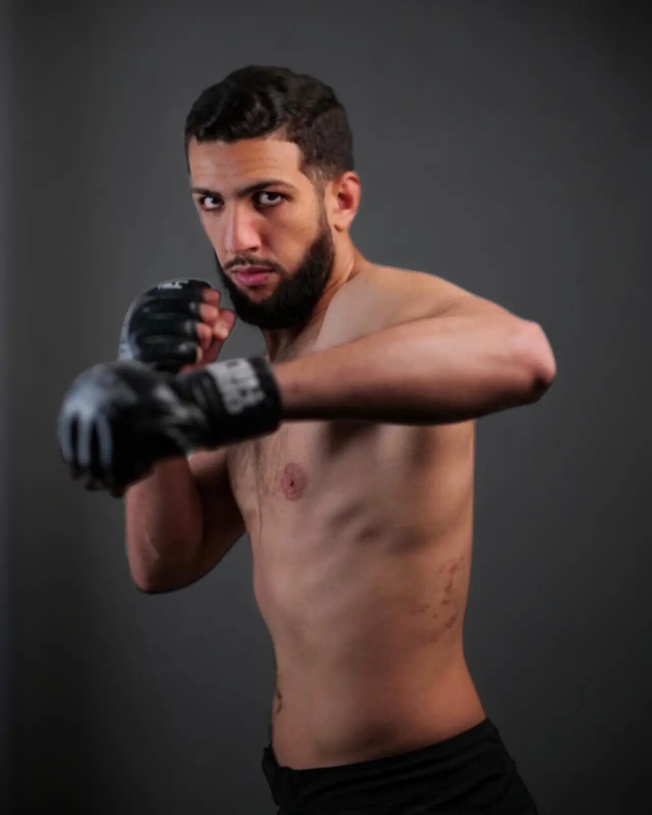 Ayoub Raouaha in a fighting stance with gloves on — Muay Thai specialist at The Alpha Club.