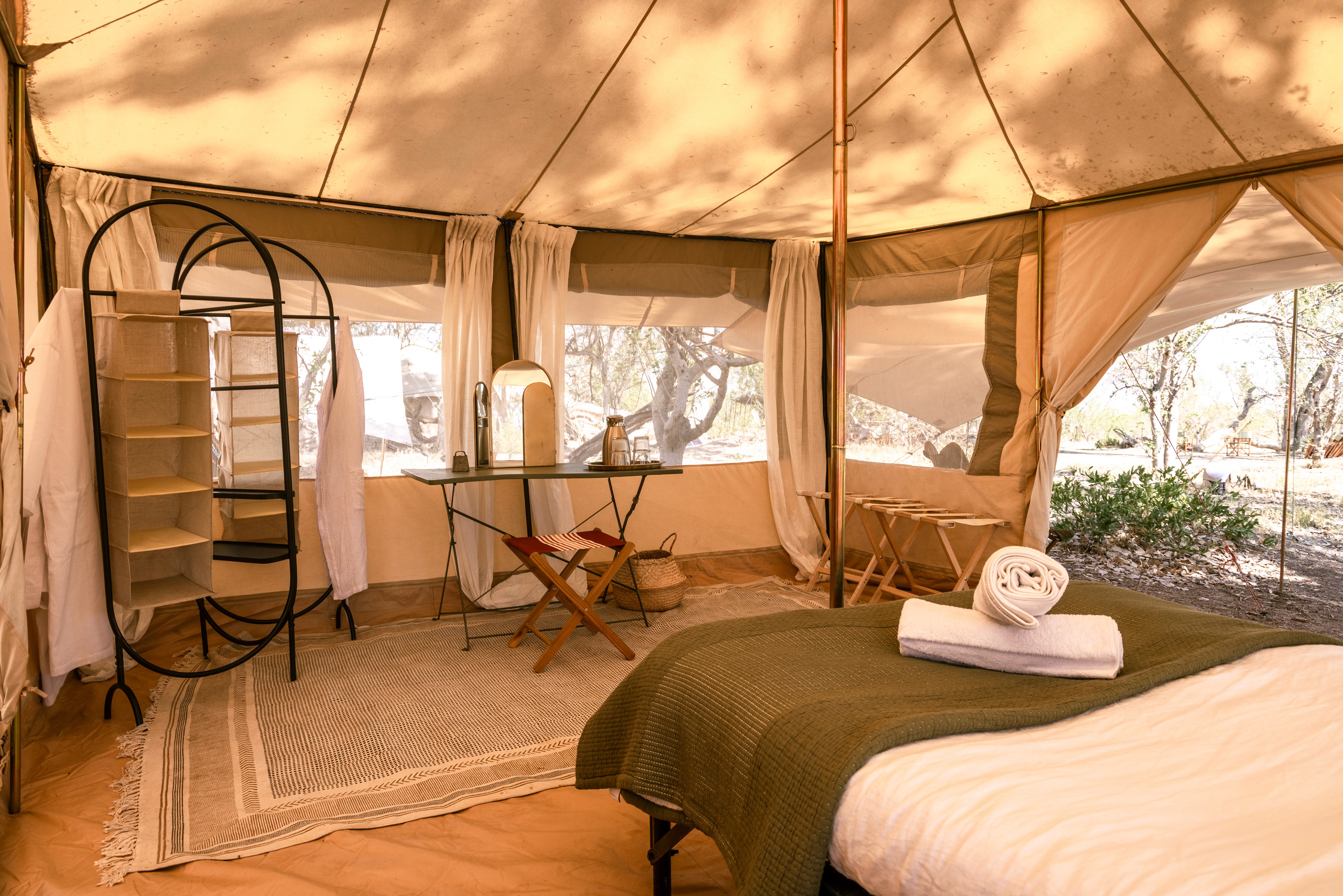 Kujwana Delta Ride, Okavango Delta, Botswana. Insidan av vackert glamping-tält uppsatt i Okavangos vildmark. Bekväma sängar, mycket utrymme och ljus upplyst.