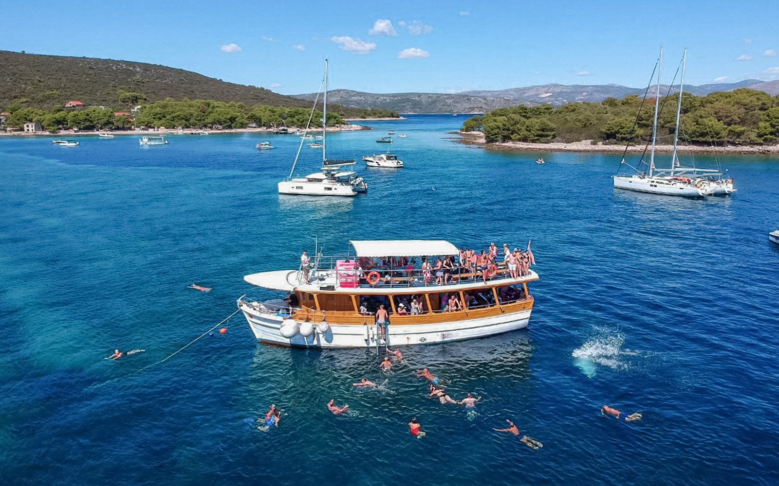 Cruise boat with swimmers near Elaphite Islands, Croatia.