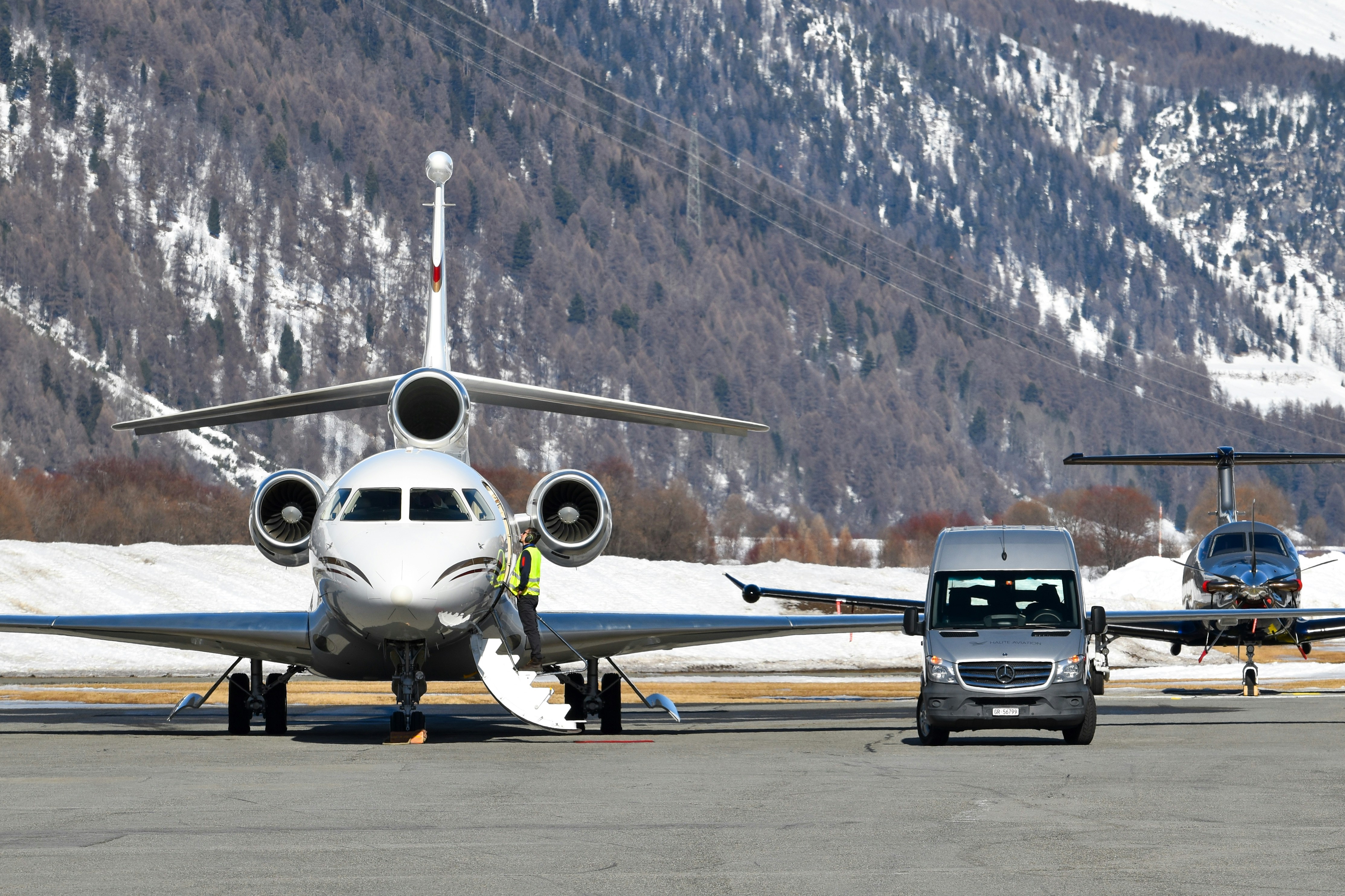 Private jets and van on snowy airport tarmac
