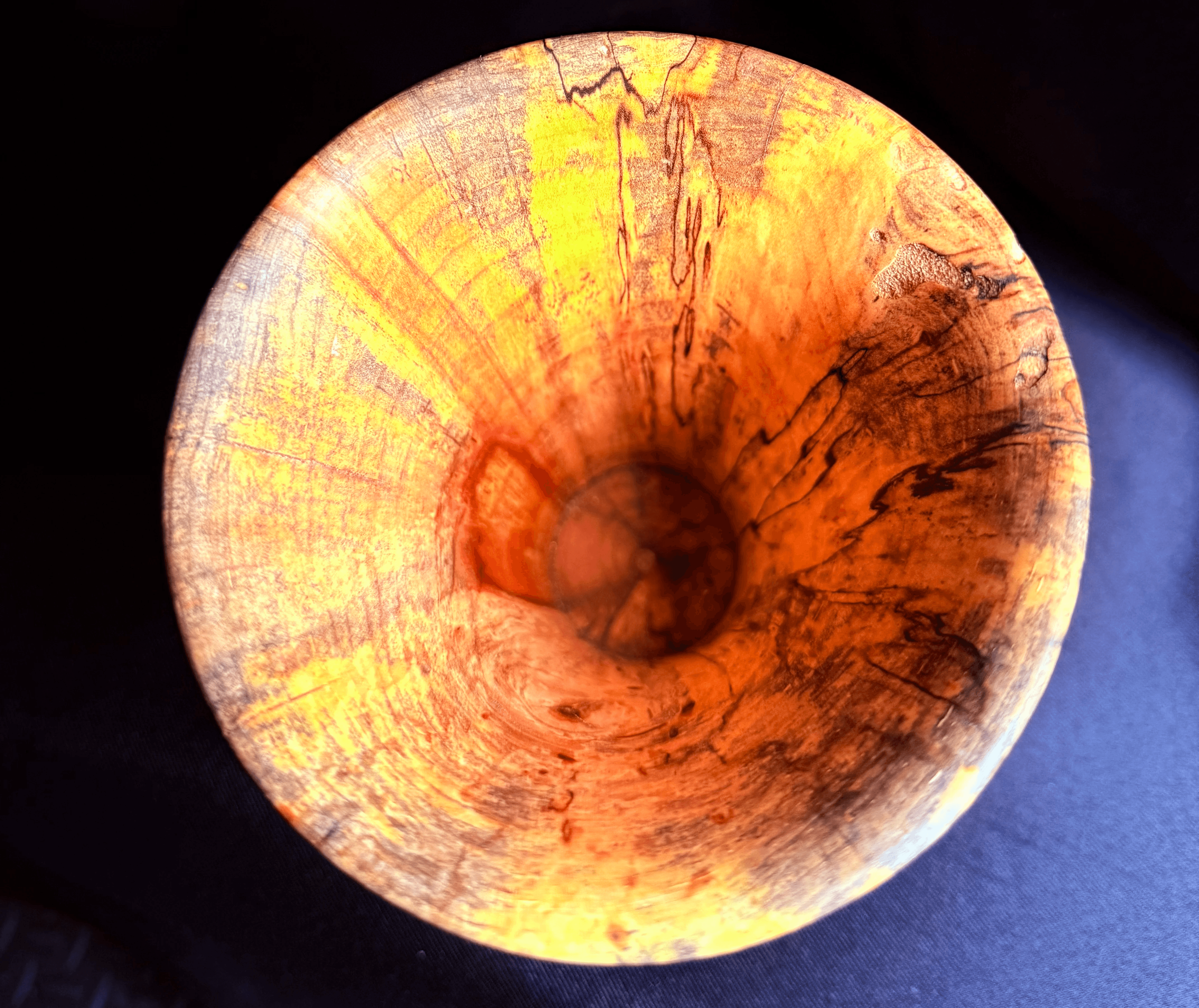Close view of the rim and interior of the hand-turned spalted ash vase.