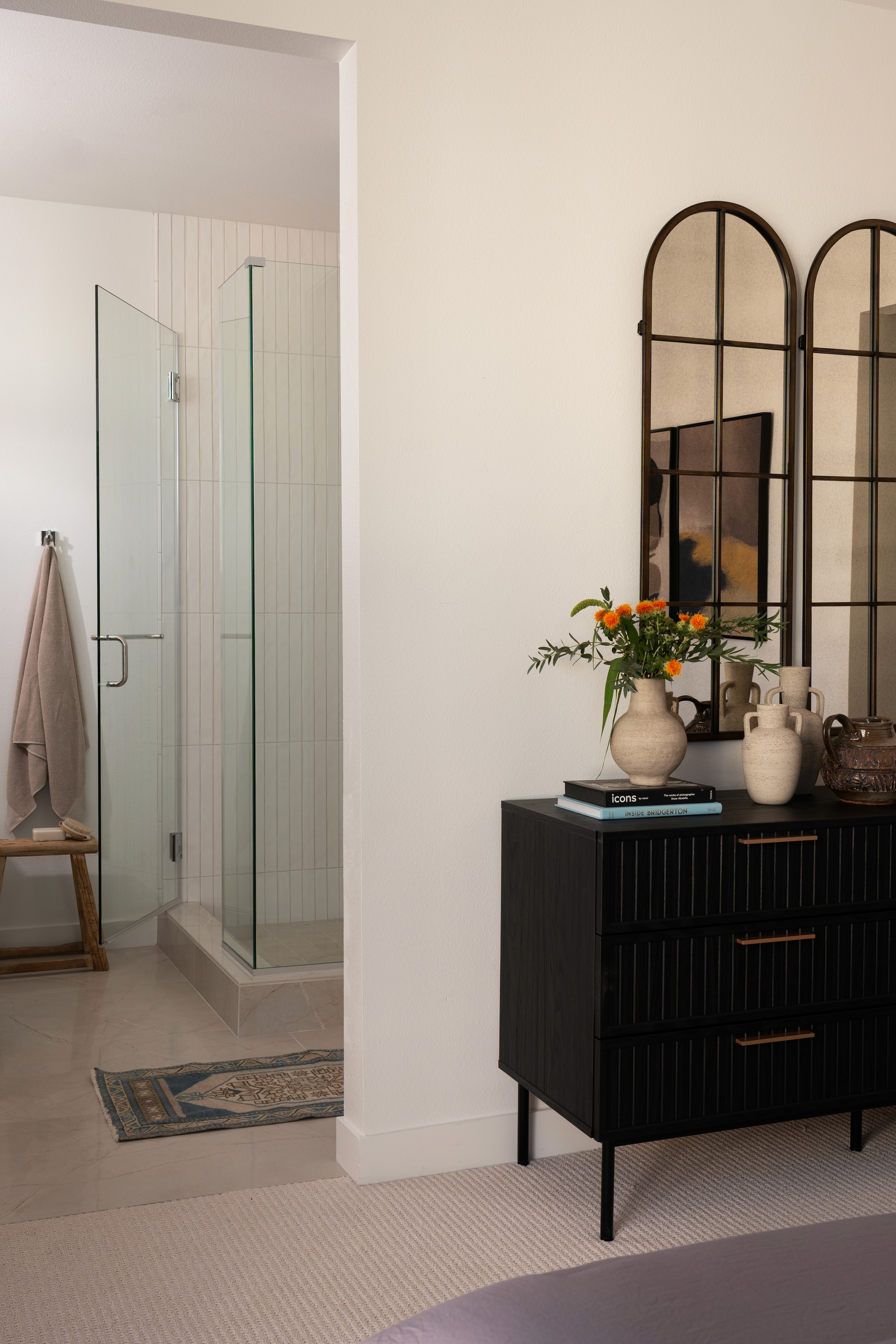 View of dresser and entry to primary bathroom