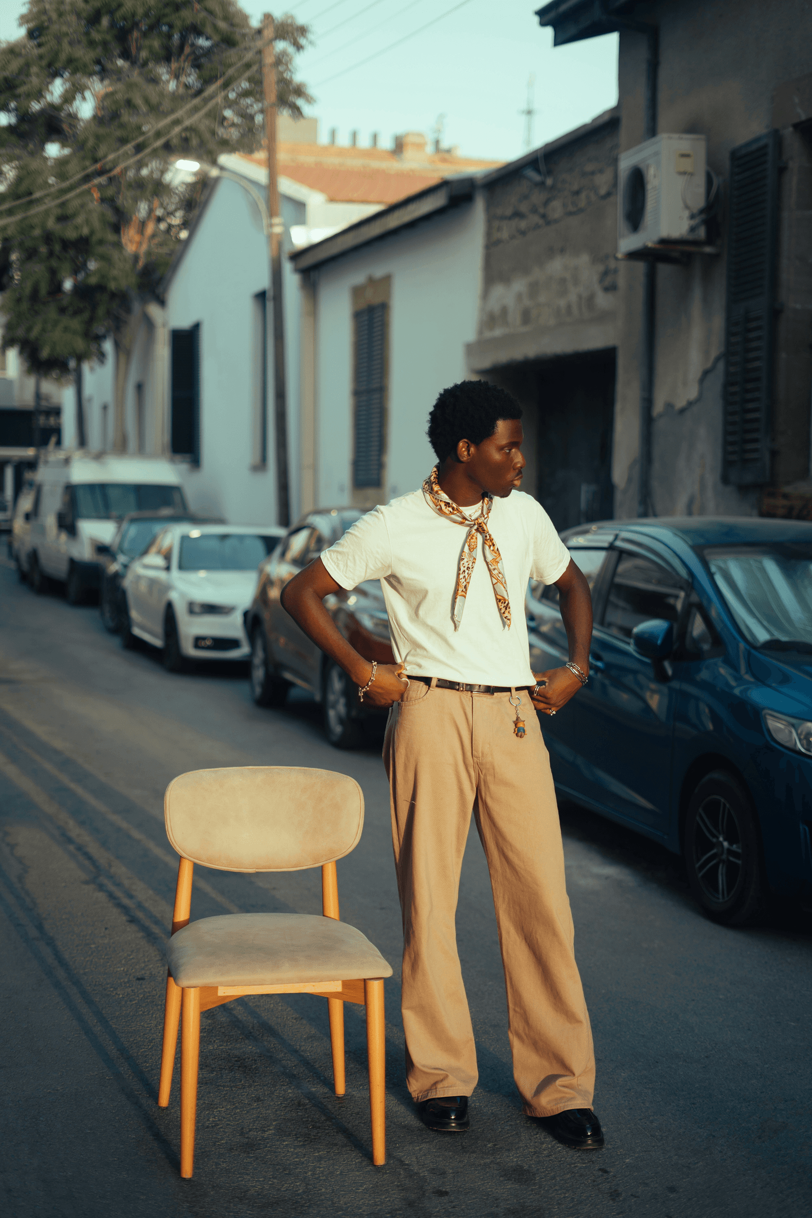Stylish man in street with chair.