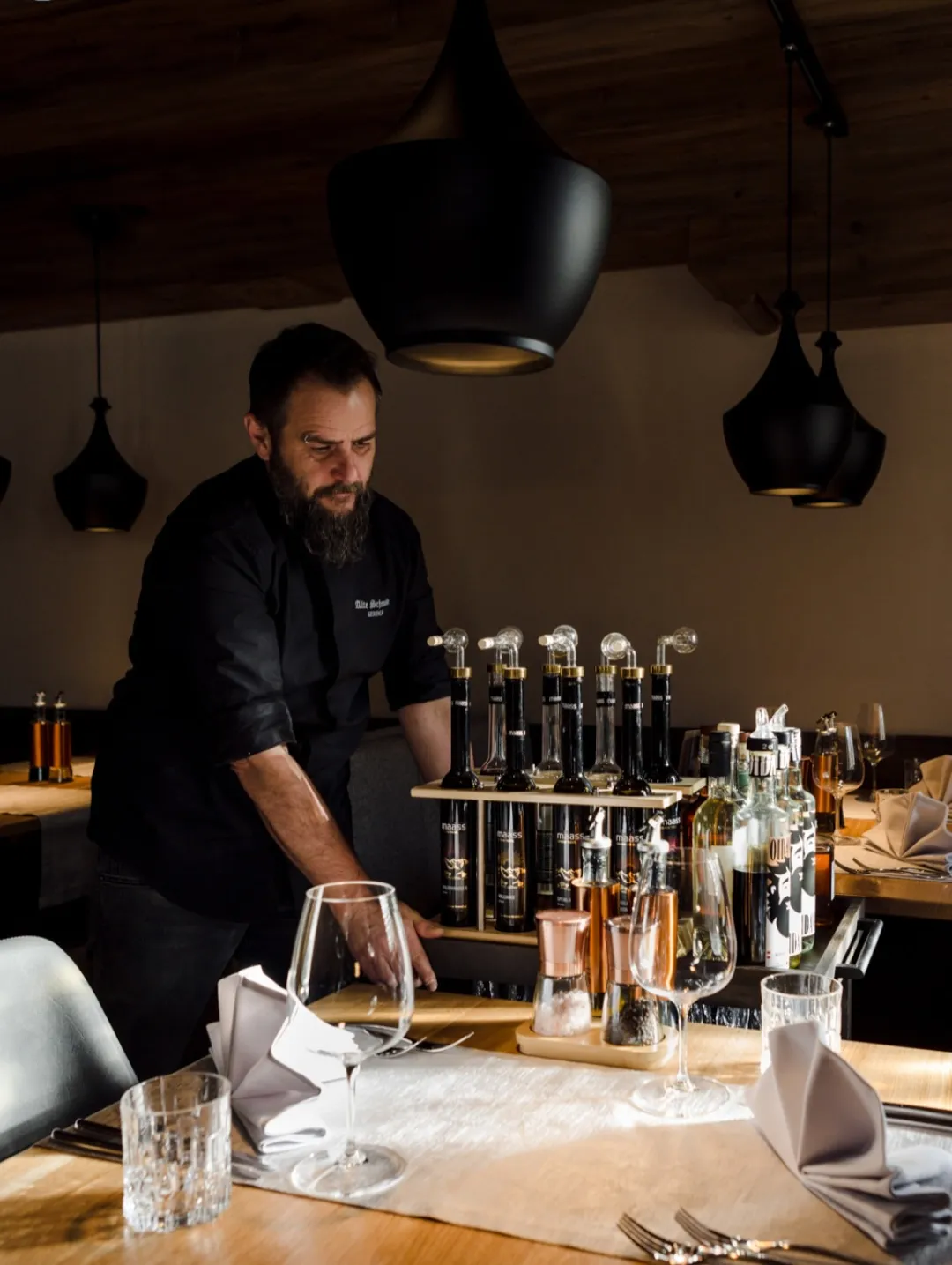 Bartender serving drinks at the bartaurant bar with glasses and stools