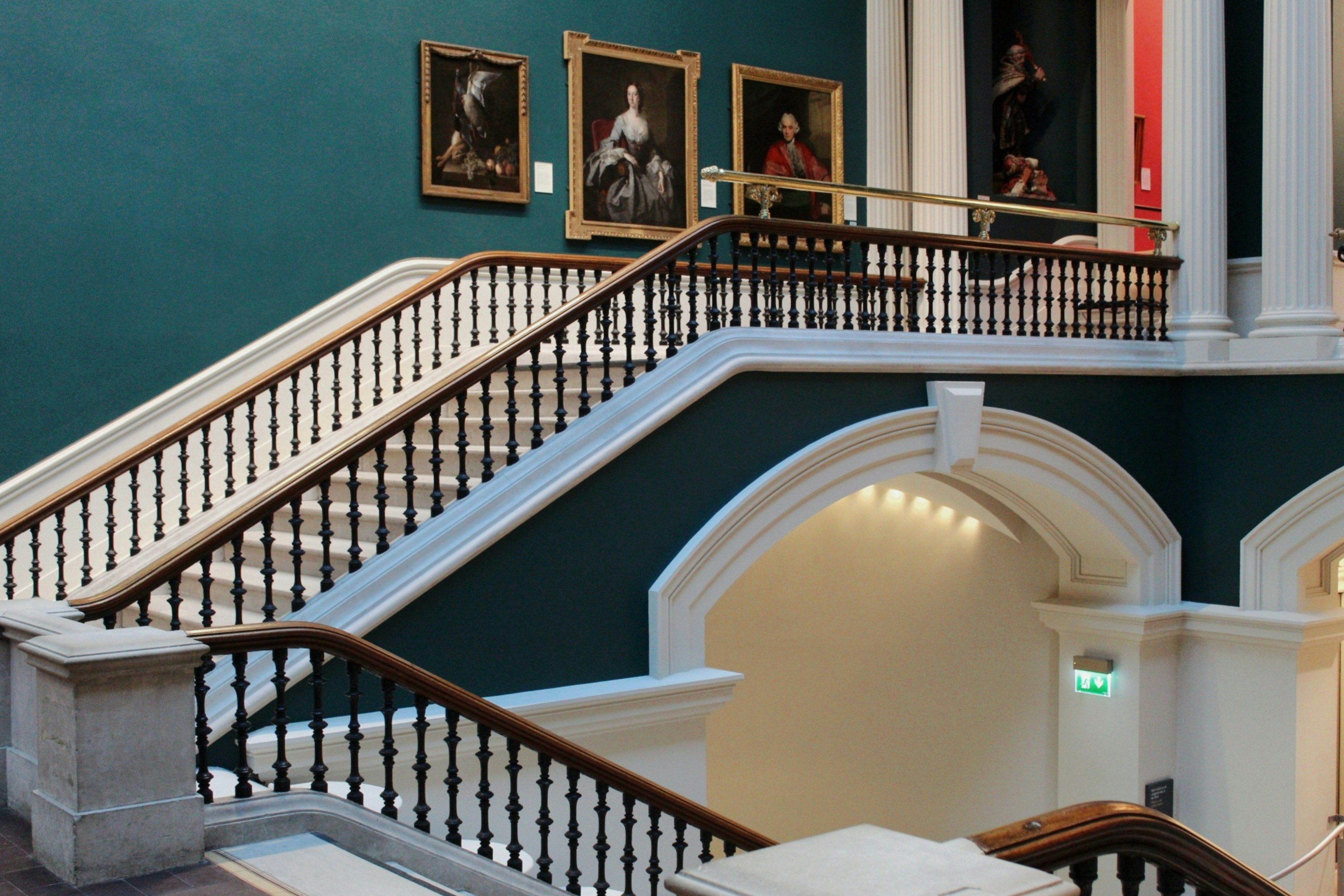 Traditional stairs with paintings displayed on the wall.