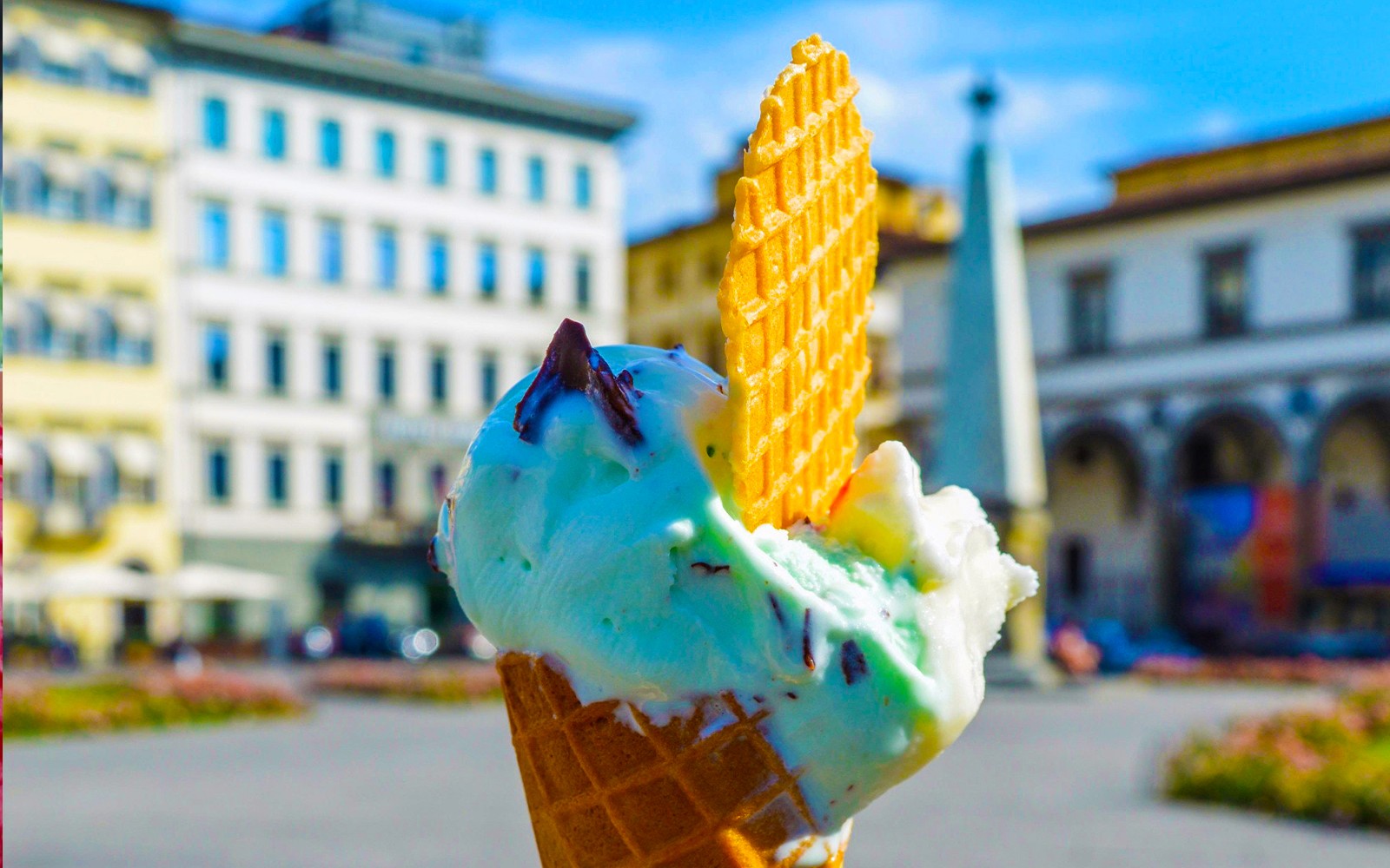 在欧洲城市广场享用一支配有威化饼干的冰淇淋甜筒。