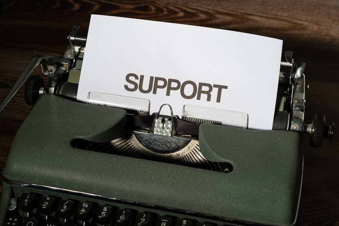 support coordinator using a laptop in a residential living room, interacting warmly with a person in a wheelchair, soft morning light