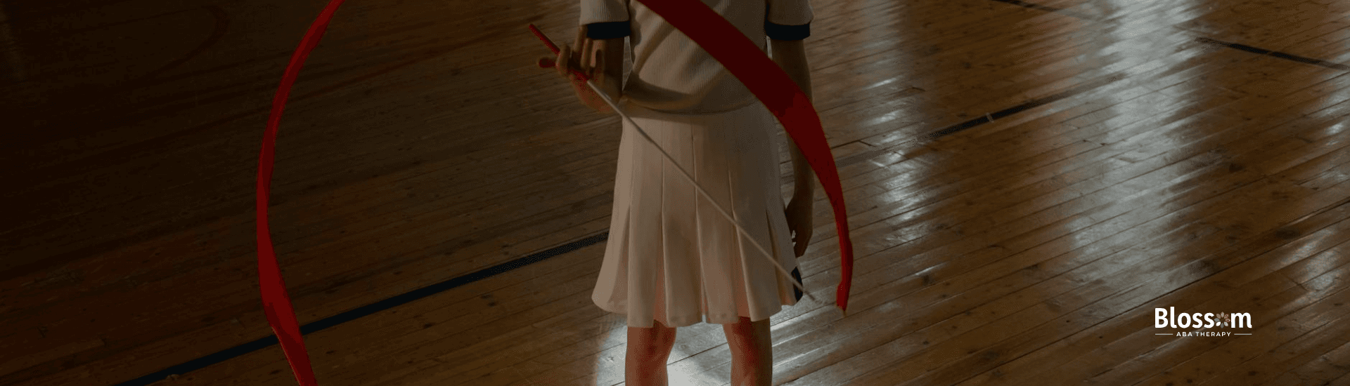 Close-up of an autistic kid's legs performing a ribbon routine on a gymnasium floor in Georgia.