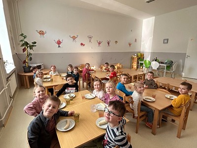 Děti společně svačící u stolečků