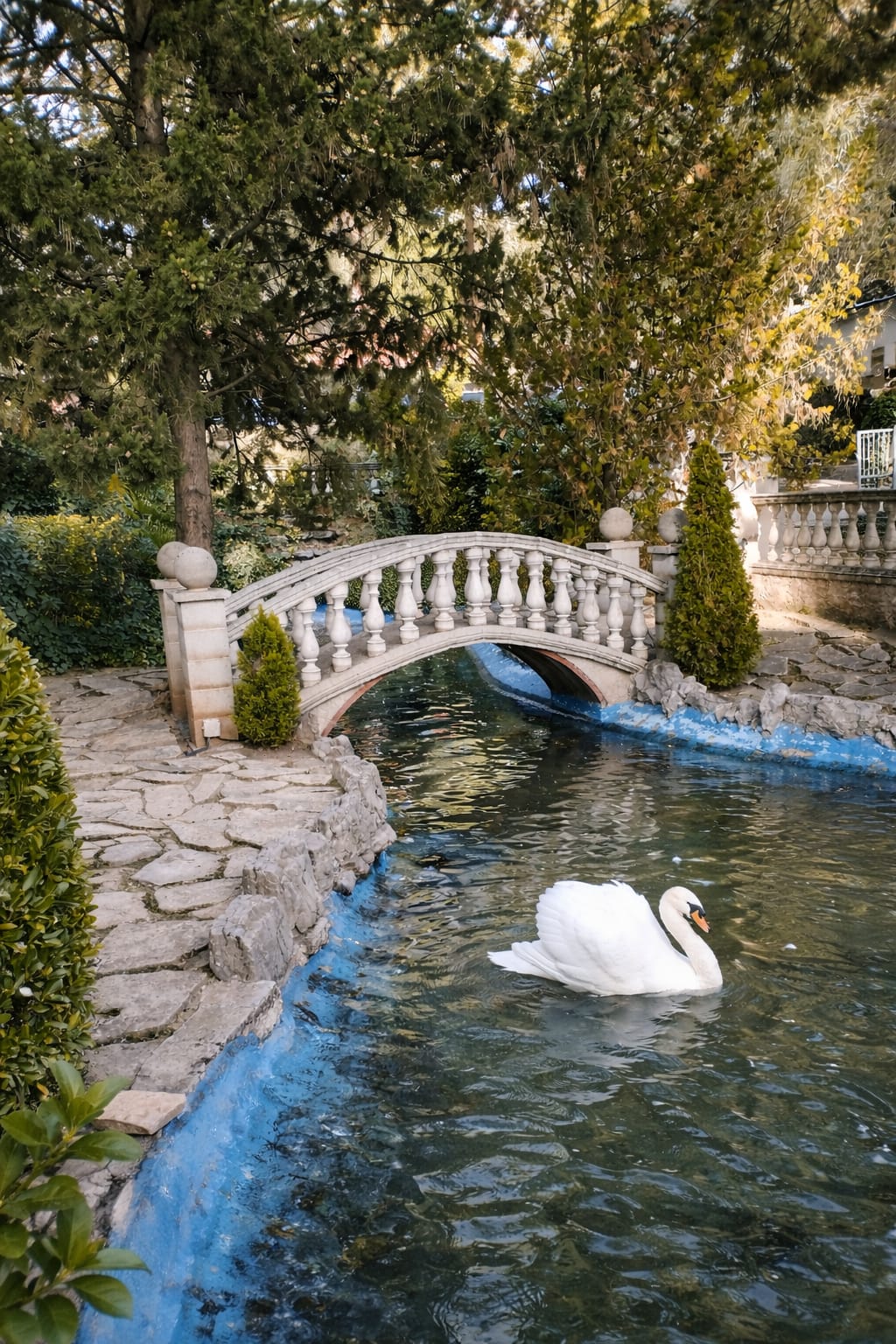 Dirt road flanked by vineyards and cypress trees, rolling hills, mist, and distant town in Tuscany.