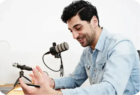 Content creator recording a podcast while working at a laptop.