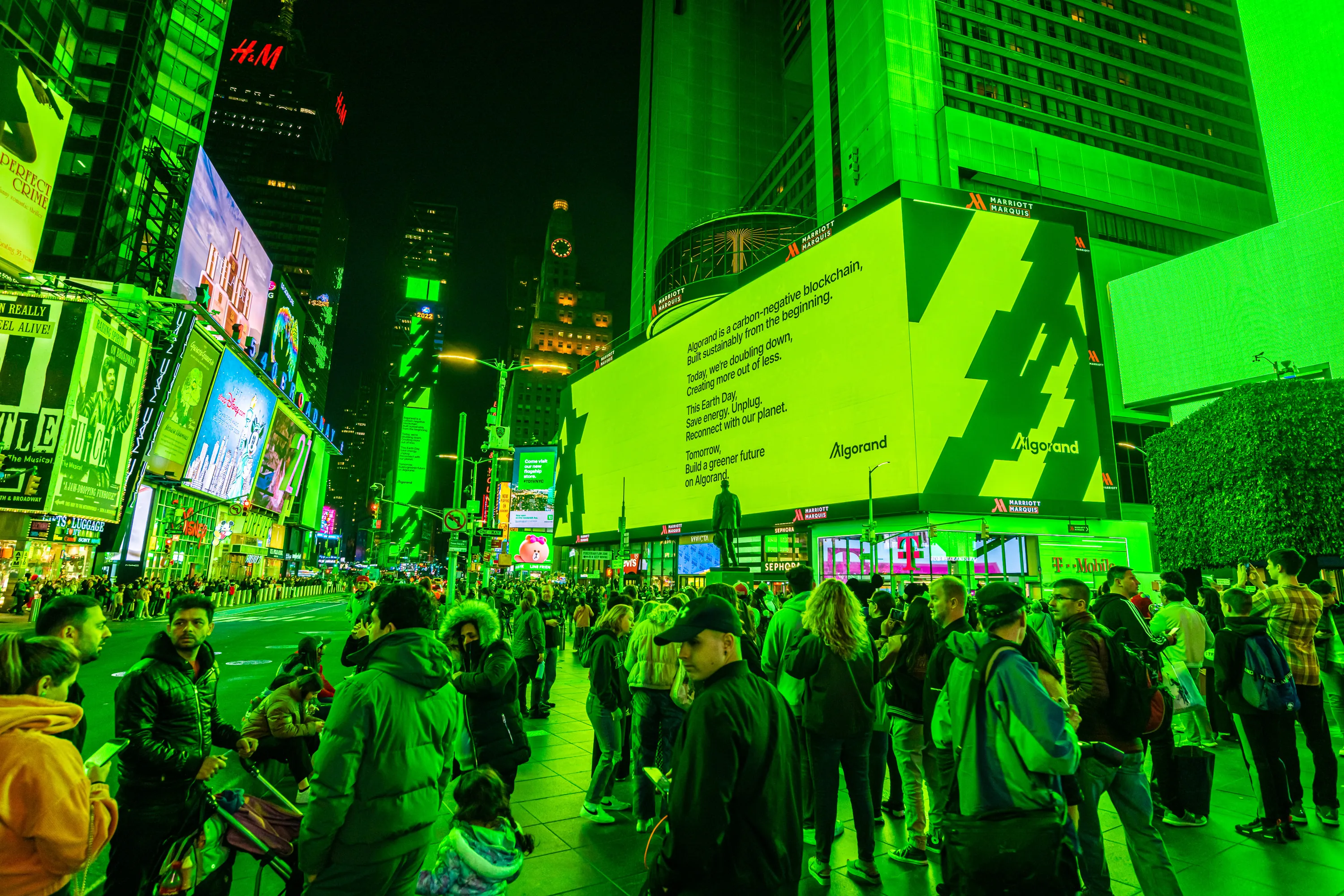 a man walking down a street past a large poster